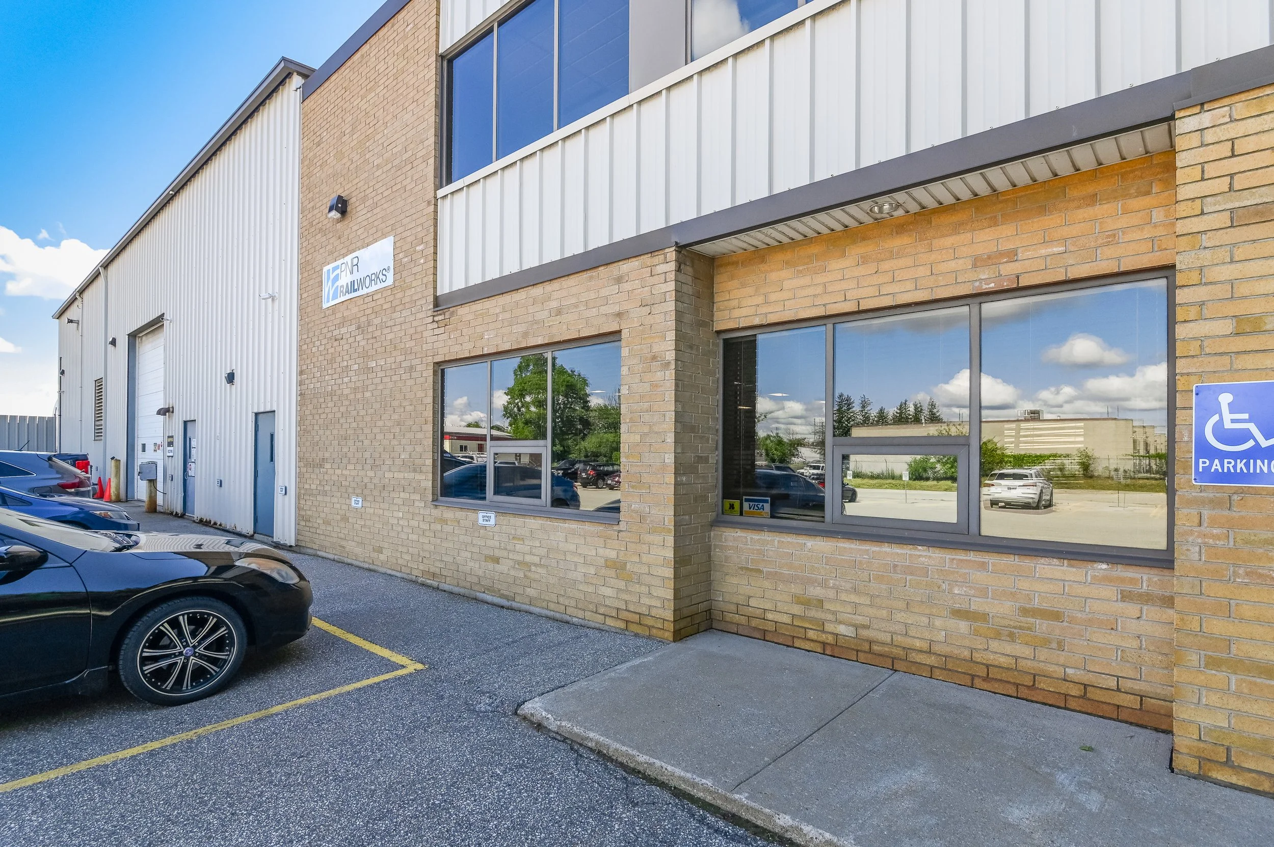 Brick office entrance with large windows at 455 Silvercreek Parkway North