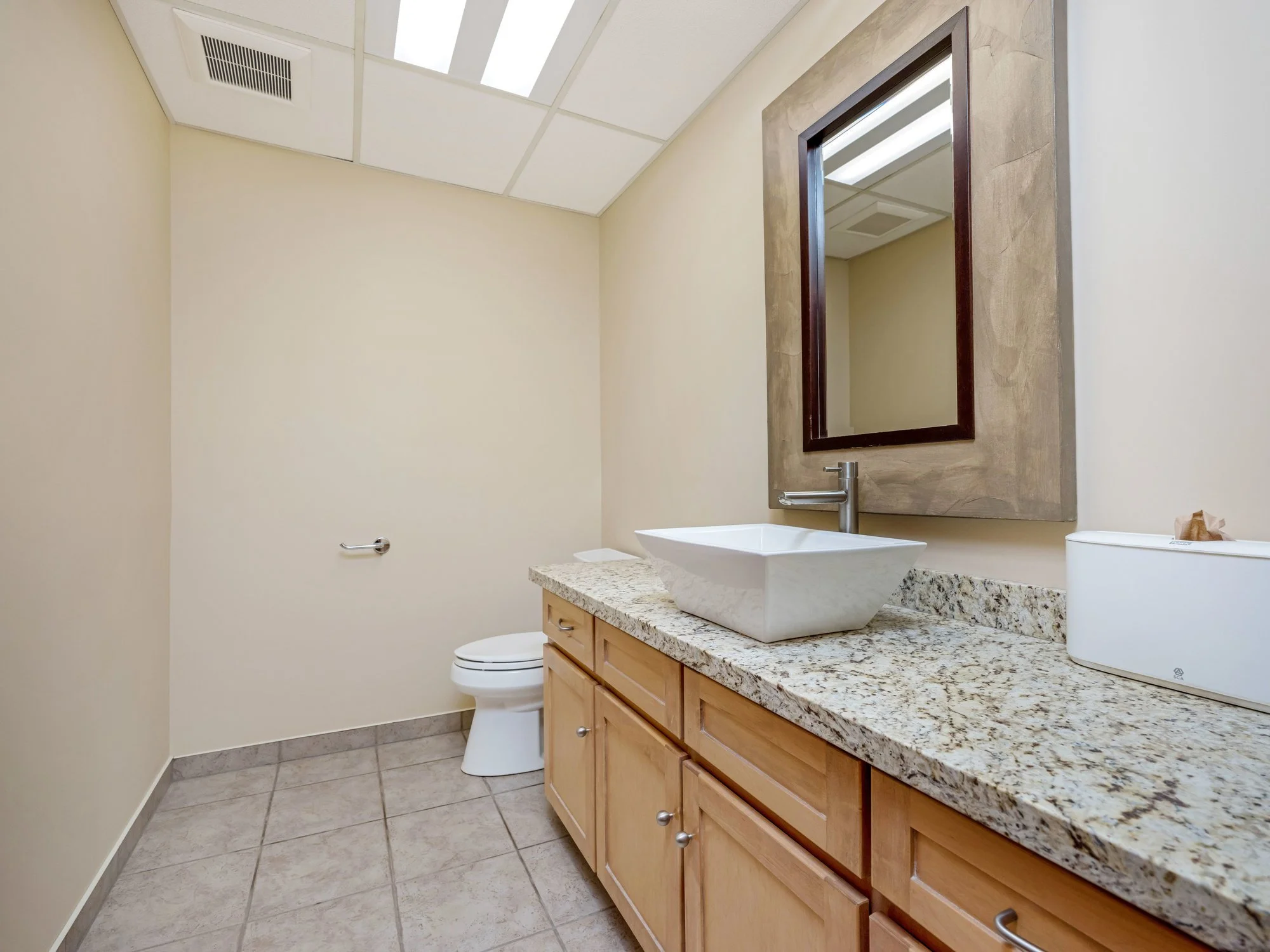 Washroom vanity with granite counter and mirror in Unit 200 at 18 Macdonell Street