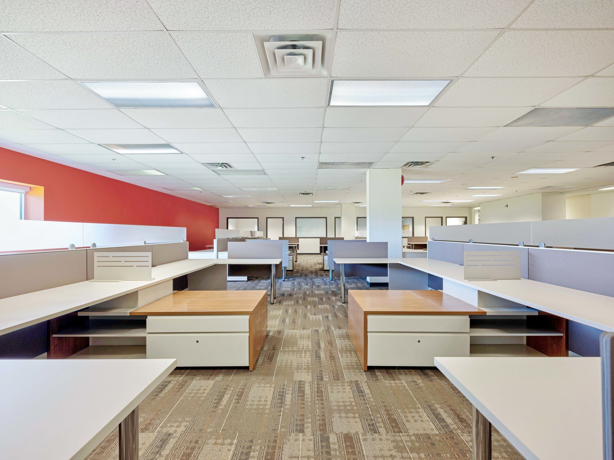 Open office area with workstations and red accent wall