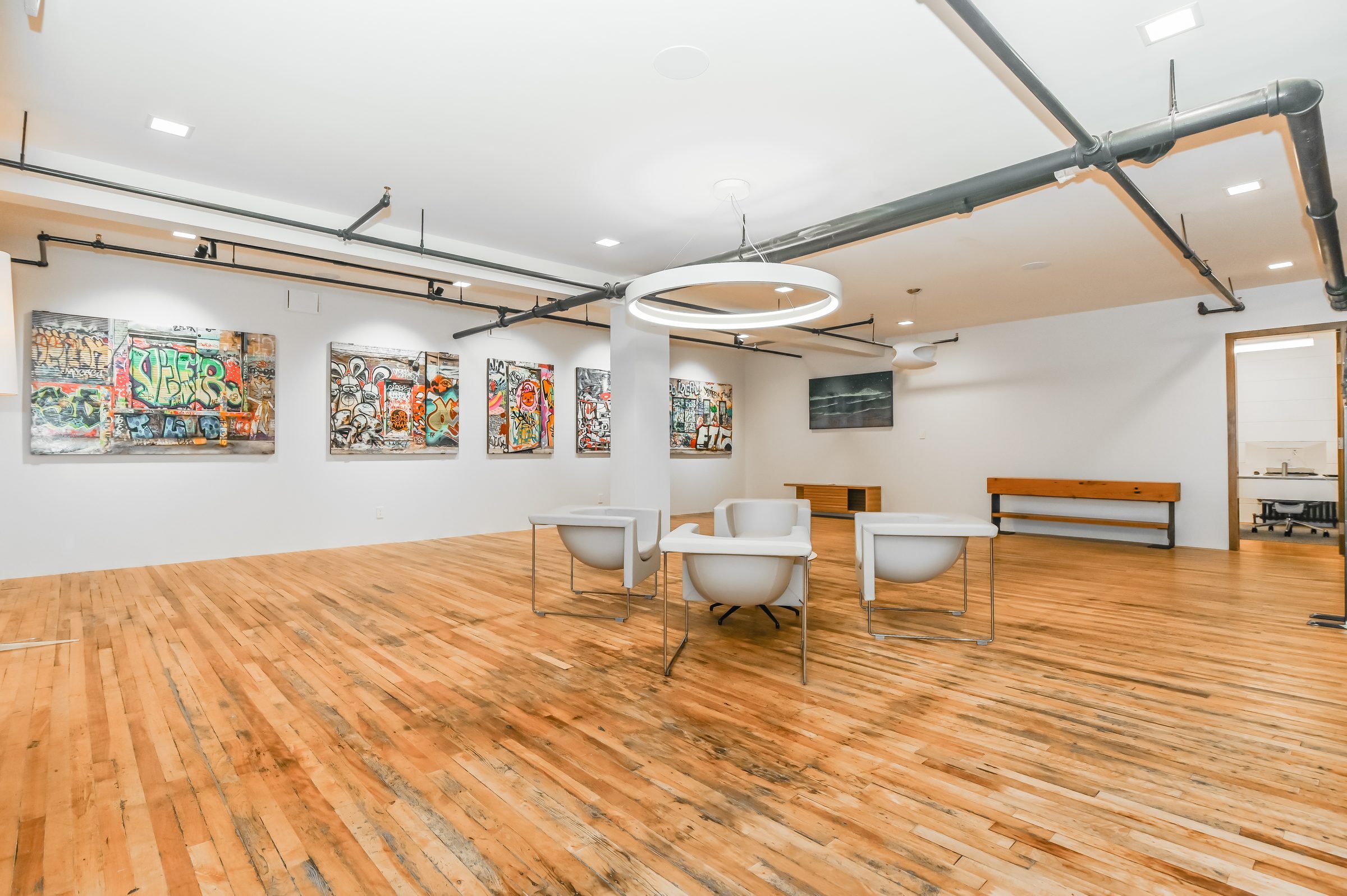 Open gallery area with hardwood floors and artwork, Unit 200, 13 Cork Street East, Guelph
