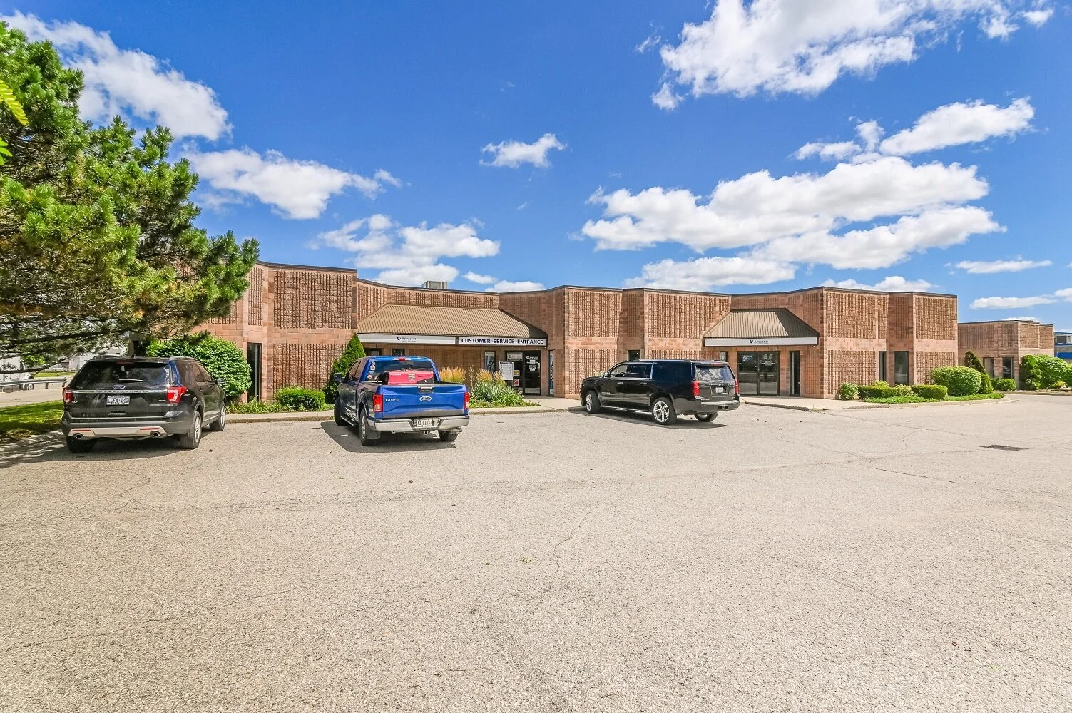 Row of brick units with parked trucks at 337 Sovereign Road