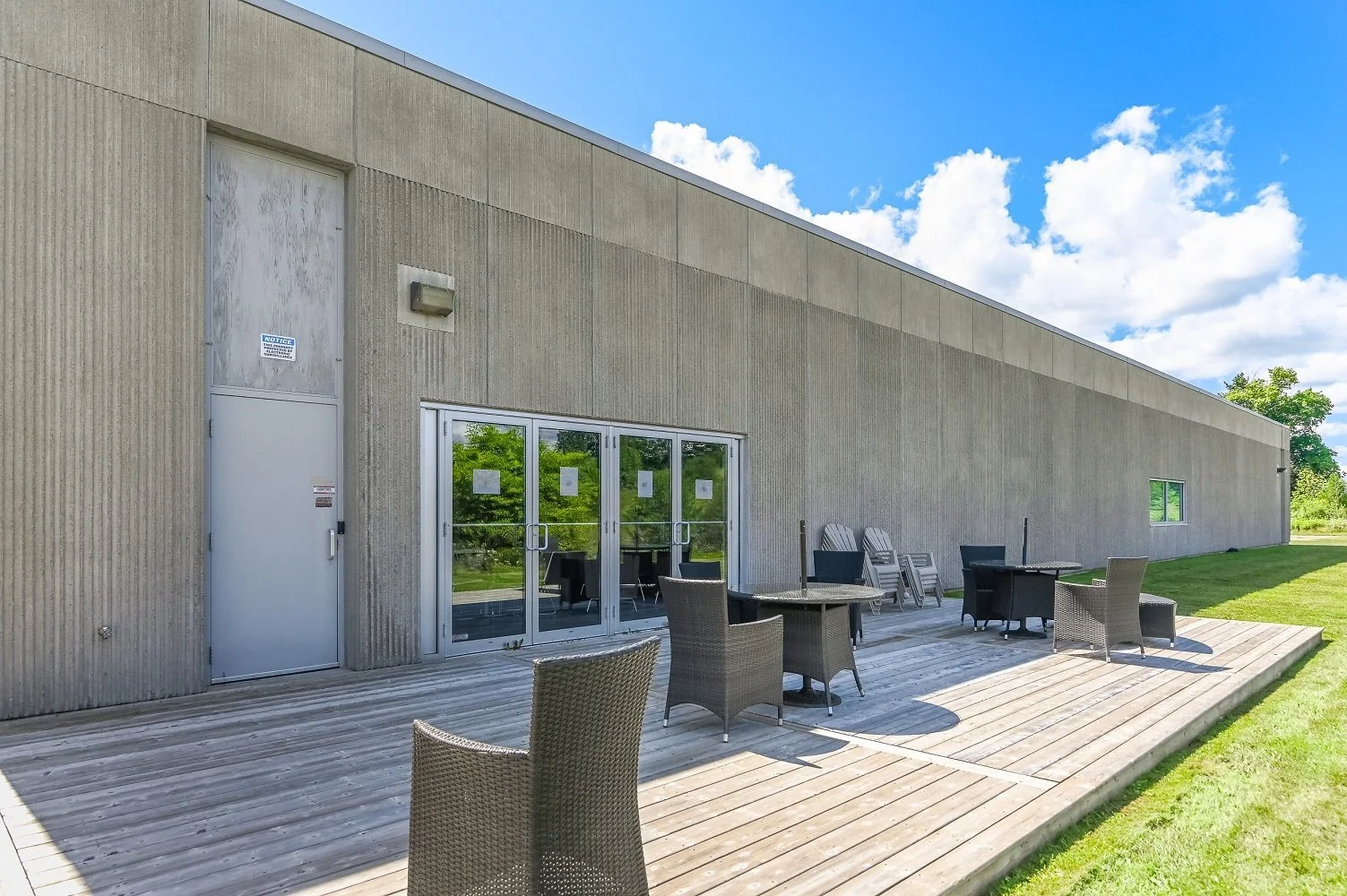 Side of the 546 Governors Road building with a wood deck, glass doors and patio furniture