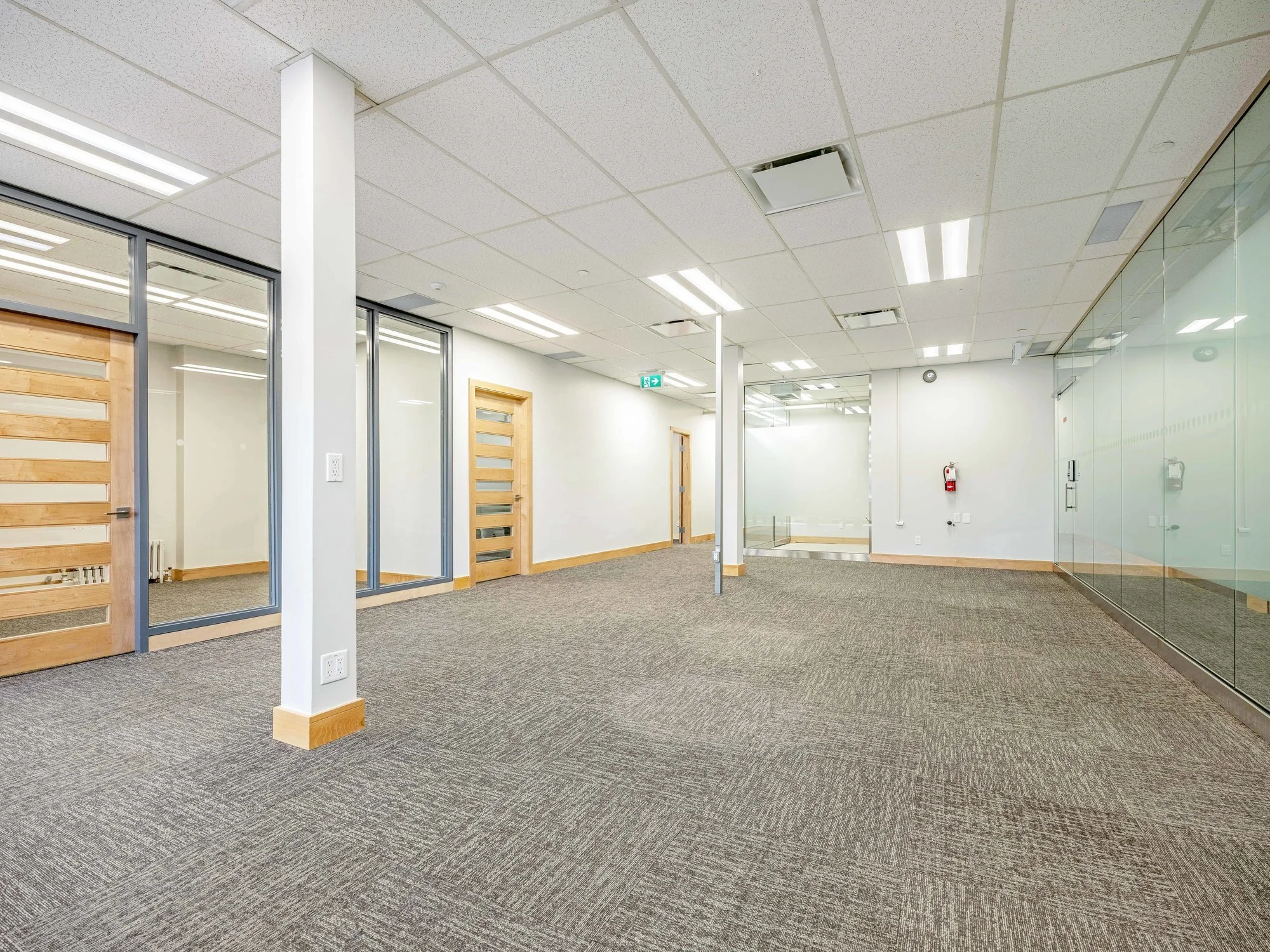 Open office floor with a structural column and glass-walled offices at 8 Macdonell Street, Unit 200A, Guelph