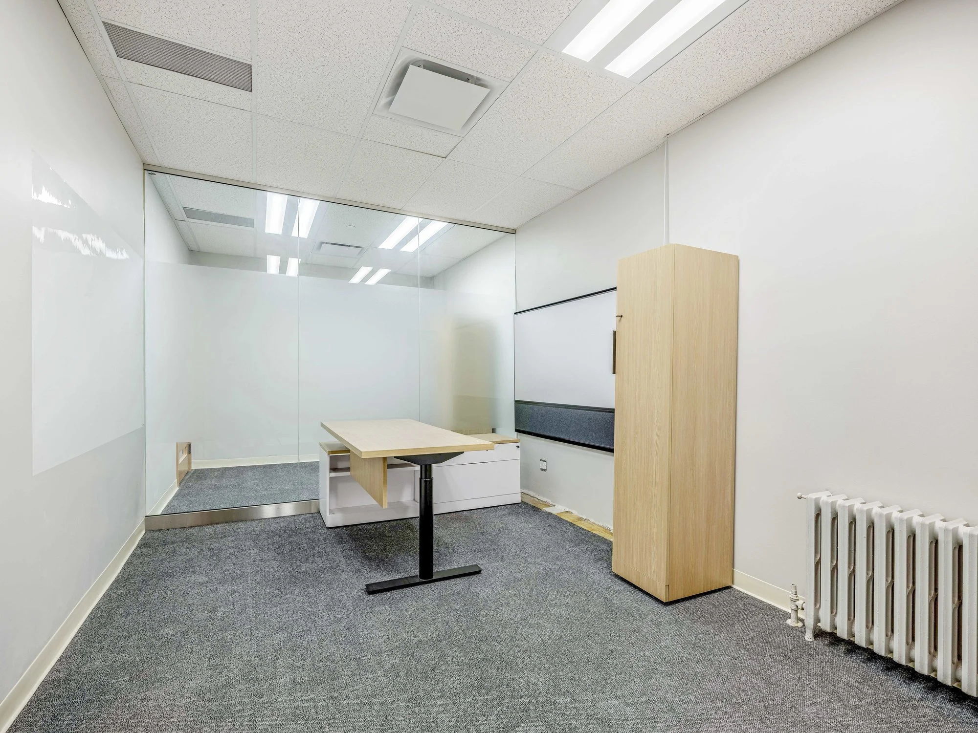 Small private office with a sit-stand desk and whiteboard wall at 8 Macdonell Street, Unit 200A, Guelph