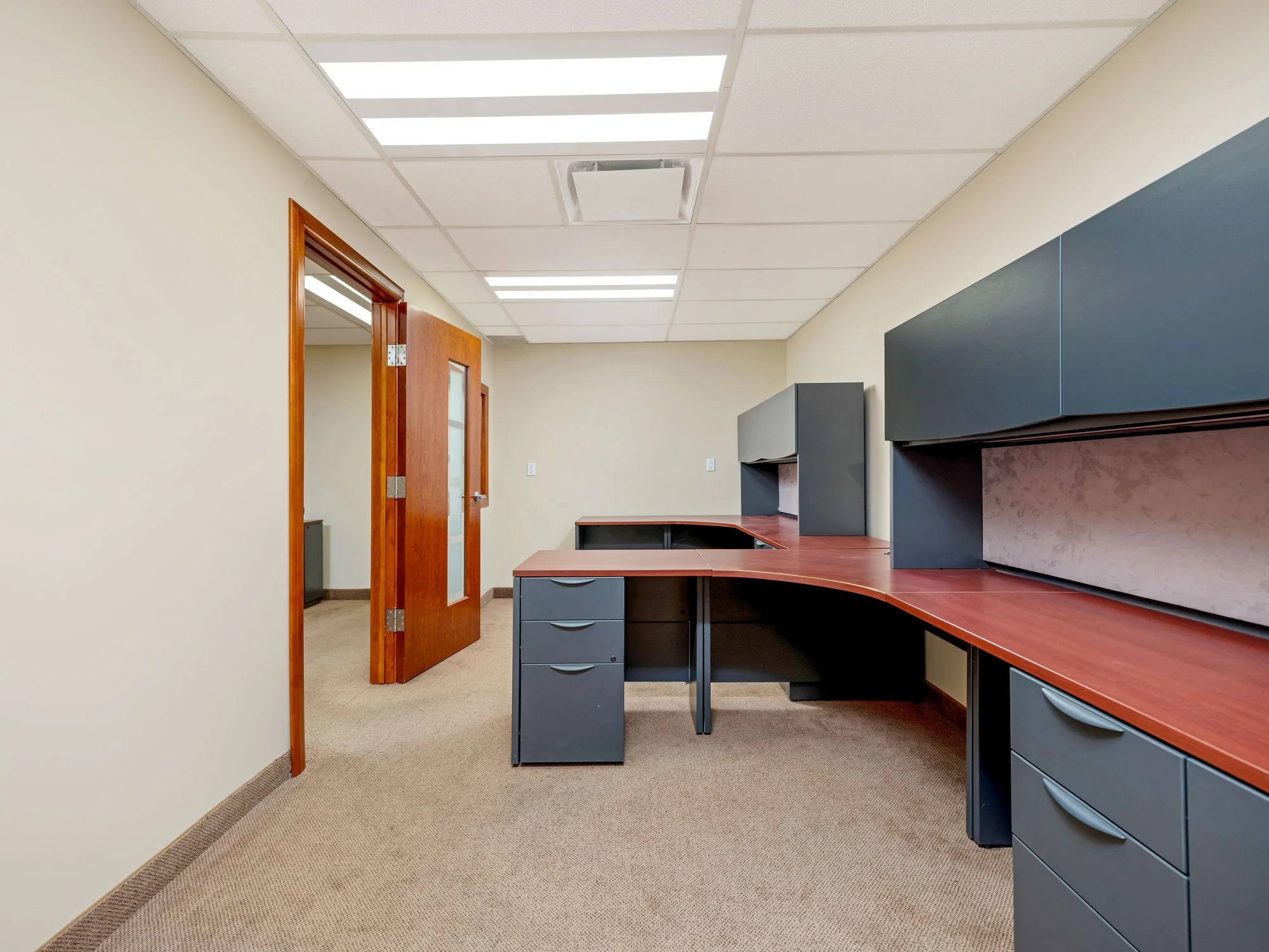 Private office with a corner desk and dark filing cabinets