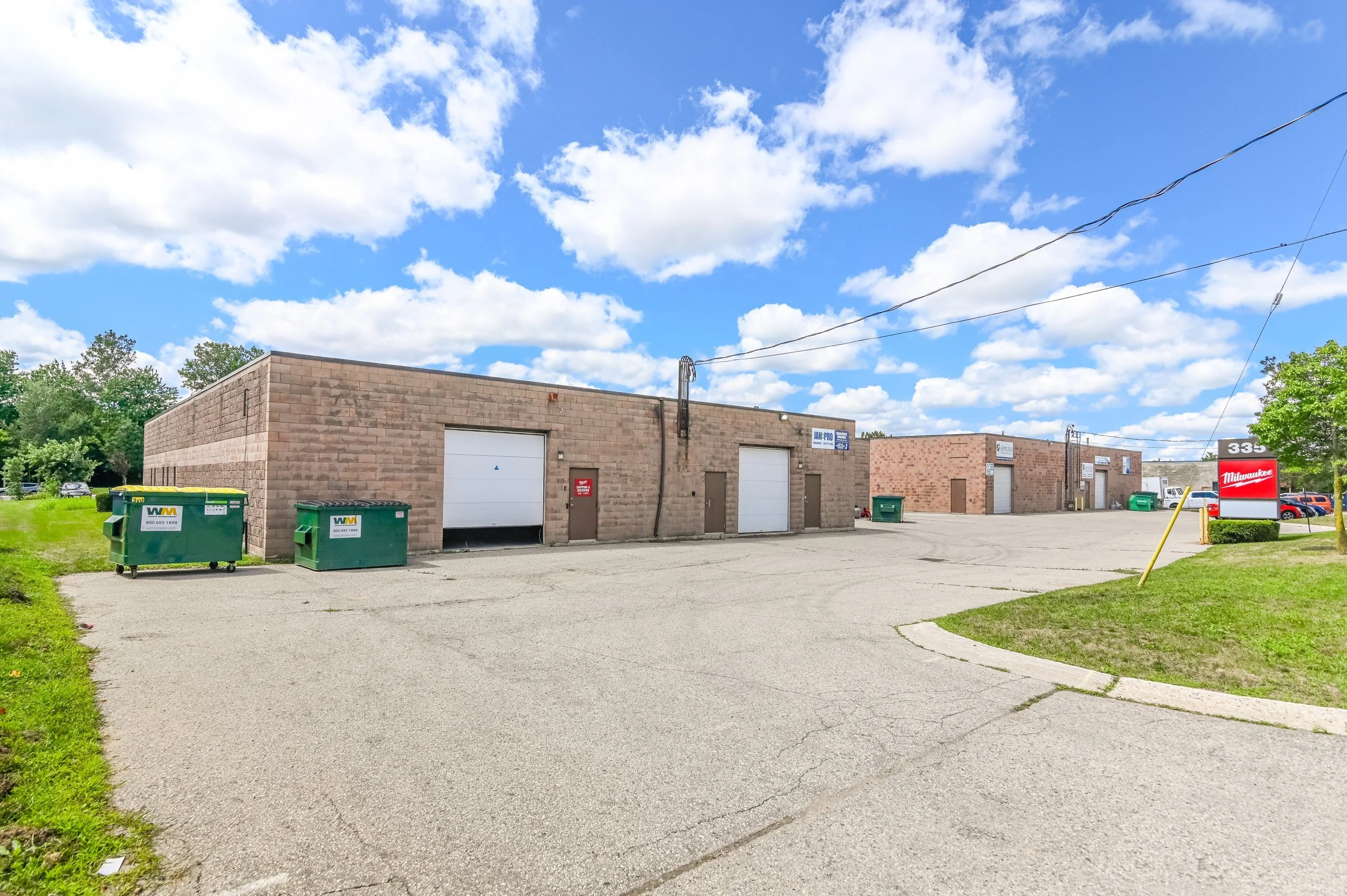 Rear of the building with overhead doors and green bins at 335 Sovereign Road