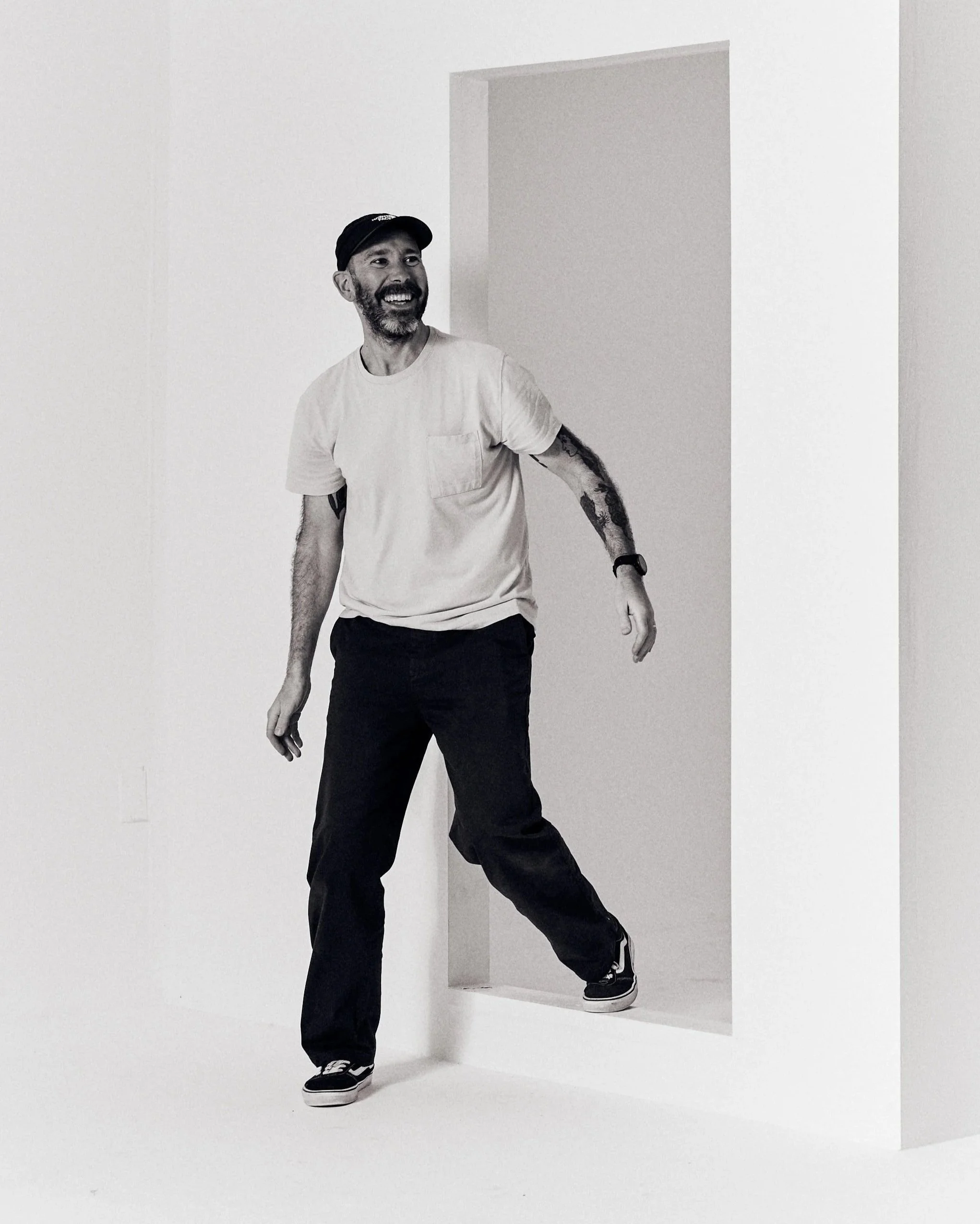 Behind-the-scenes portrait of photographer Aaron Conway walking out of a build set in his studio.