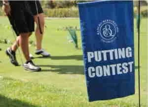 Flag with text 'Putting Contest' on a golf course.