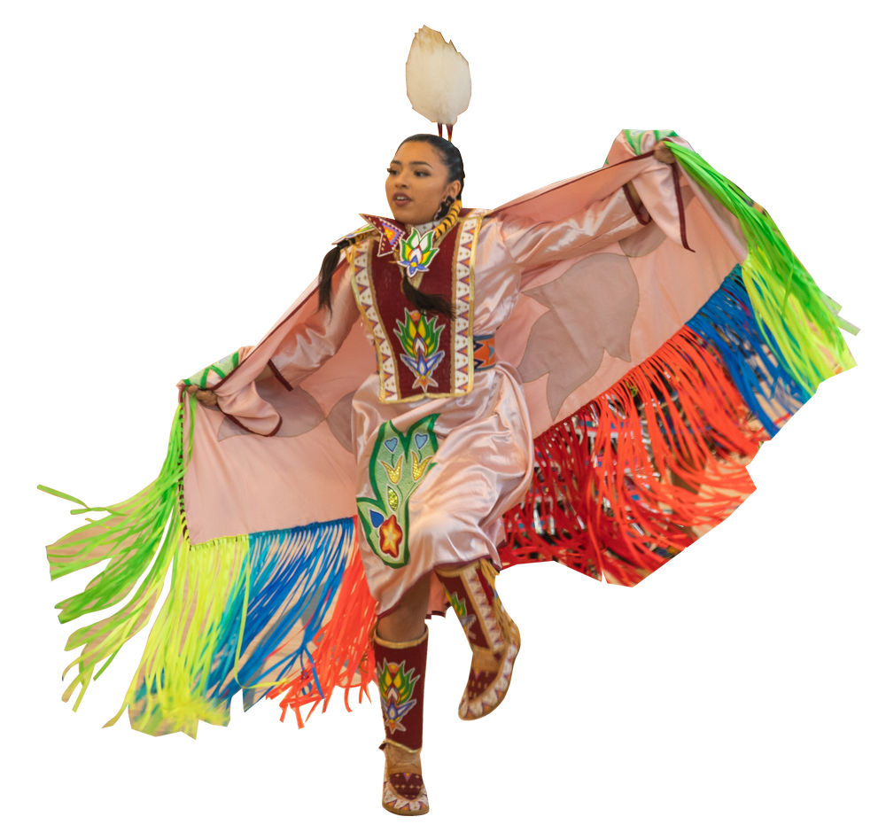 Person in vibrant traditional Mexican dance costume with colorful fringe, embroidery, and decorative patterns, performing a dance move.