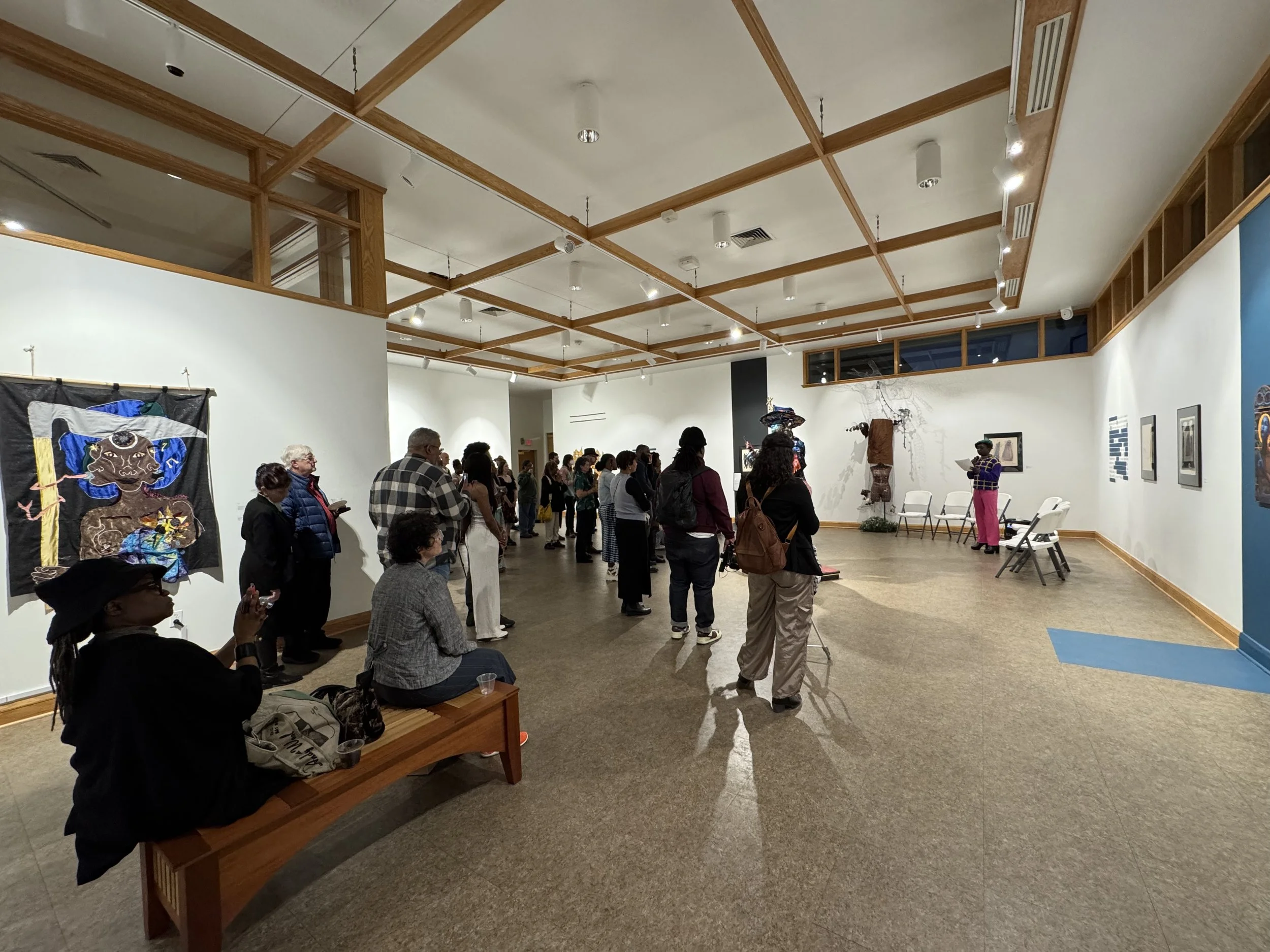 crowd of people in the gallery with guest curator speaking