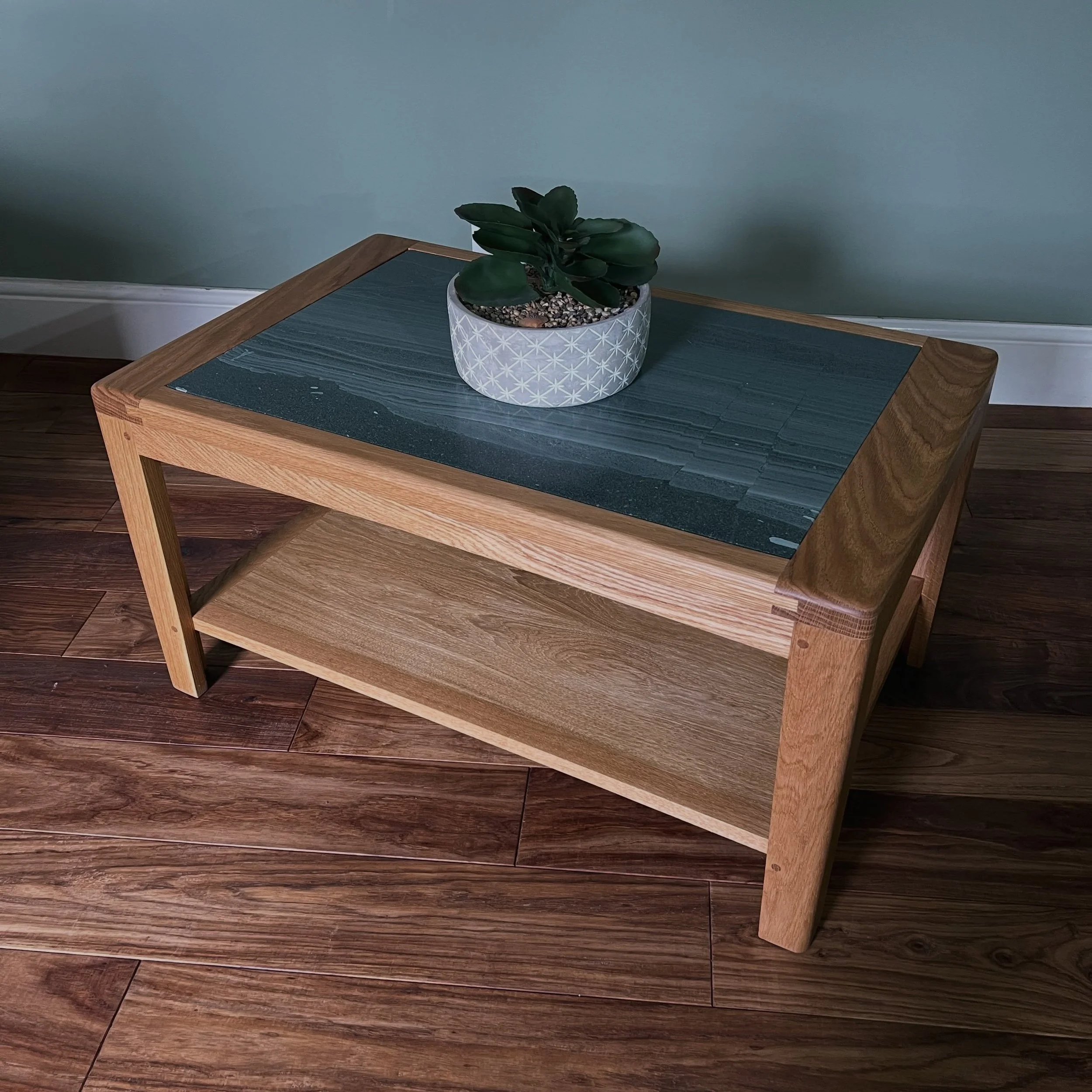 This solid oak coffee table was made recently and holds a special piece of green slate that was taken from the original flooring in the clients home in Nottinghamshire. We made it using traditional joint techniques, simple rounded edges, and clean li