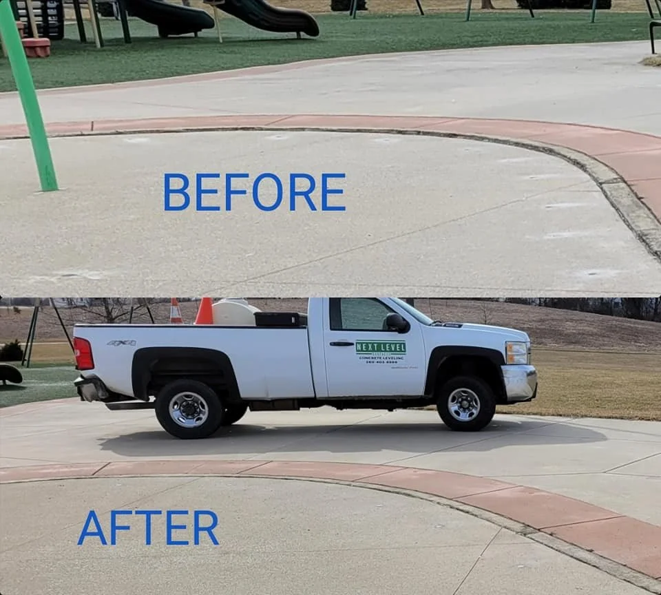 Side view of a white pickup truck with a sign on the door that says 'Next Level' parked on a concrete surface in an outdoor area with grass and playground equipment in the background.