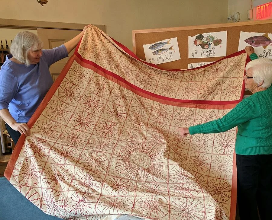 A quilt with hand stitched signatures of early congregants