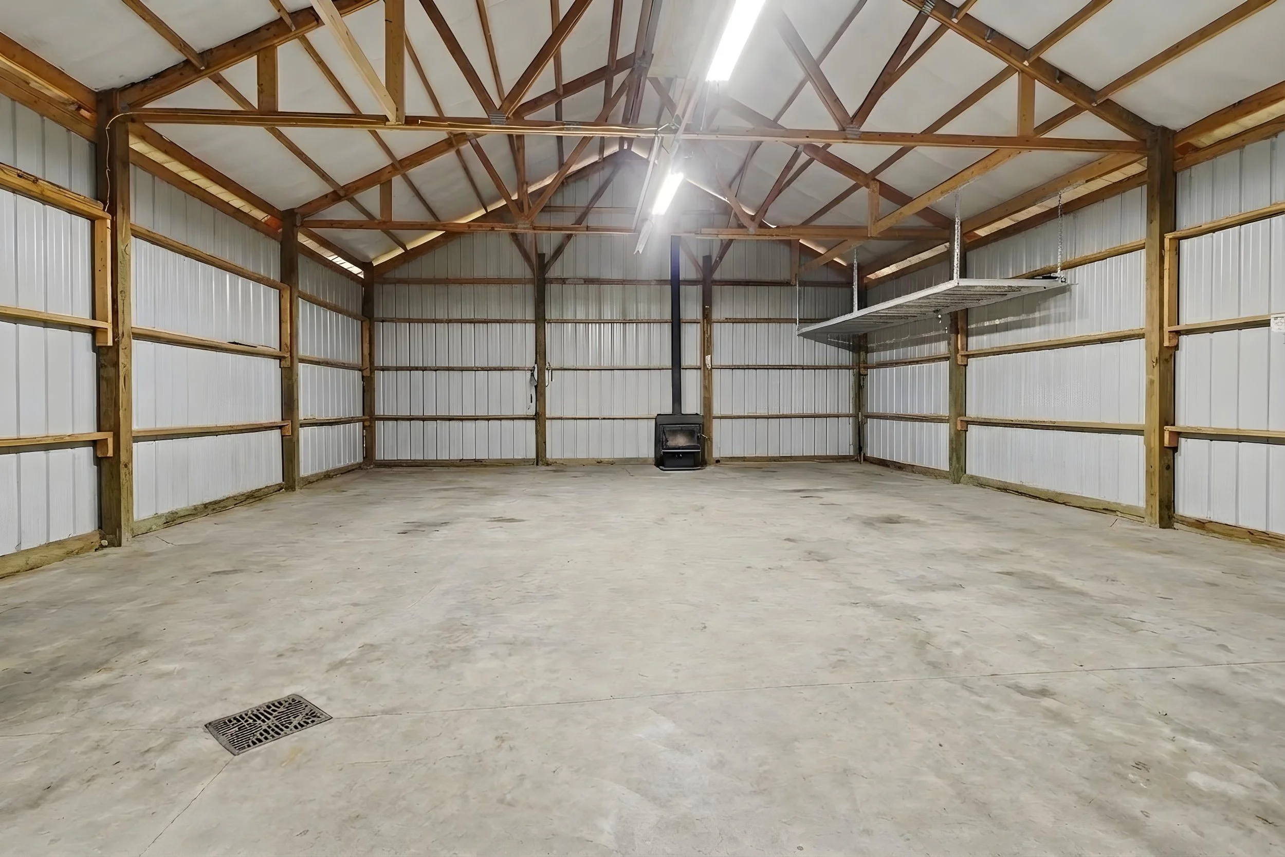 Picture of the inside of the pole barn at 10850 W J Avenue, Kalamazoo, Mi.  The pole barn has a cement floor and drain.
