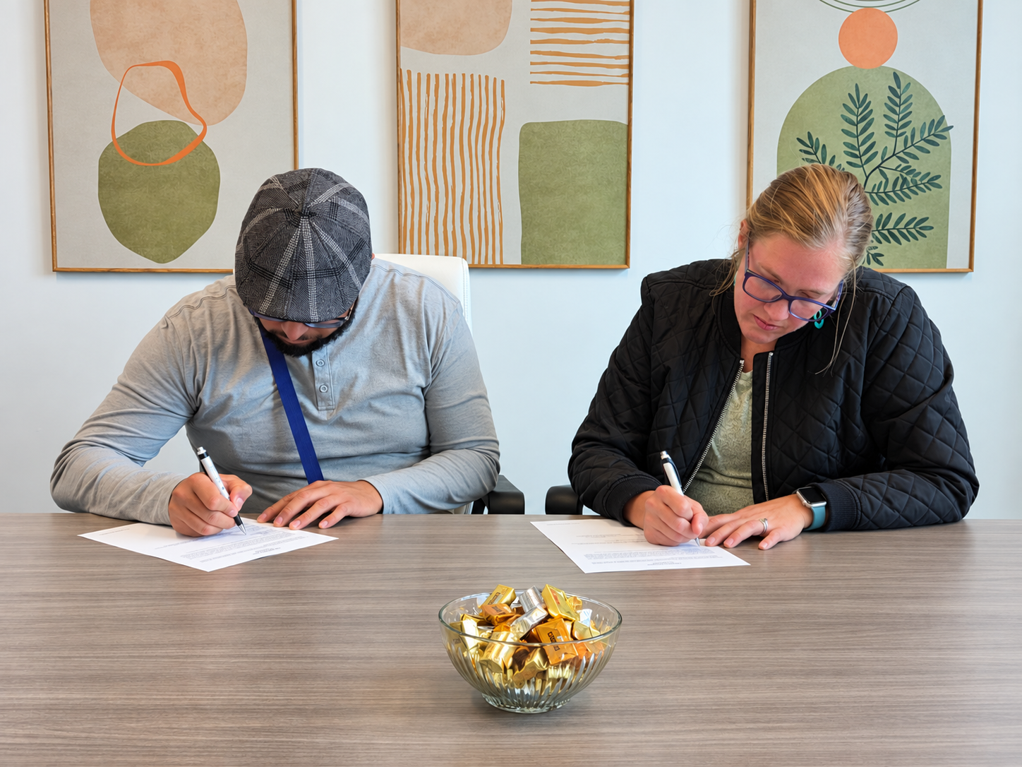Joel and Annette sign documents at the closing table for their home in Wyoming, Michigan.