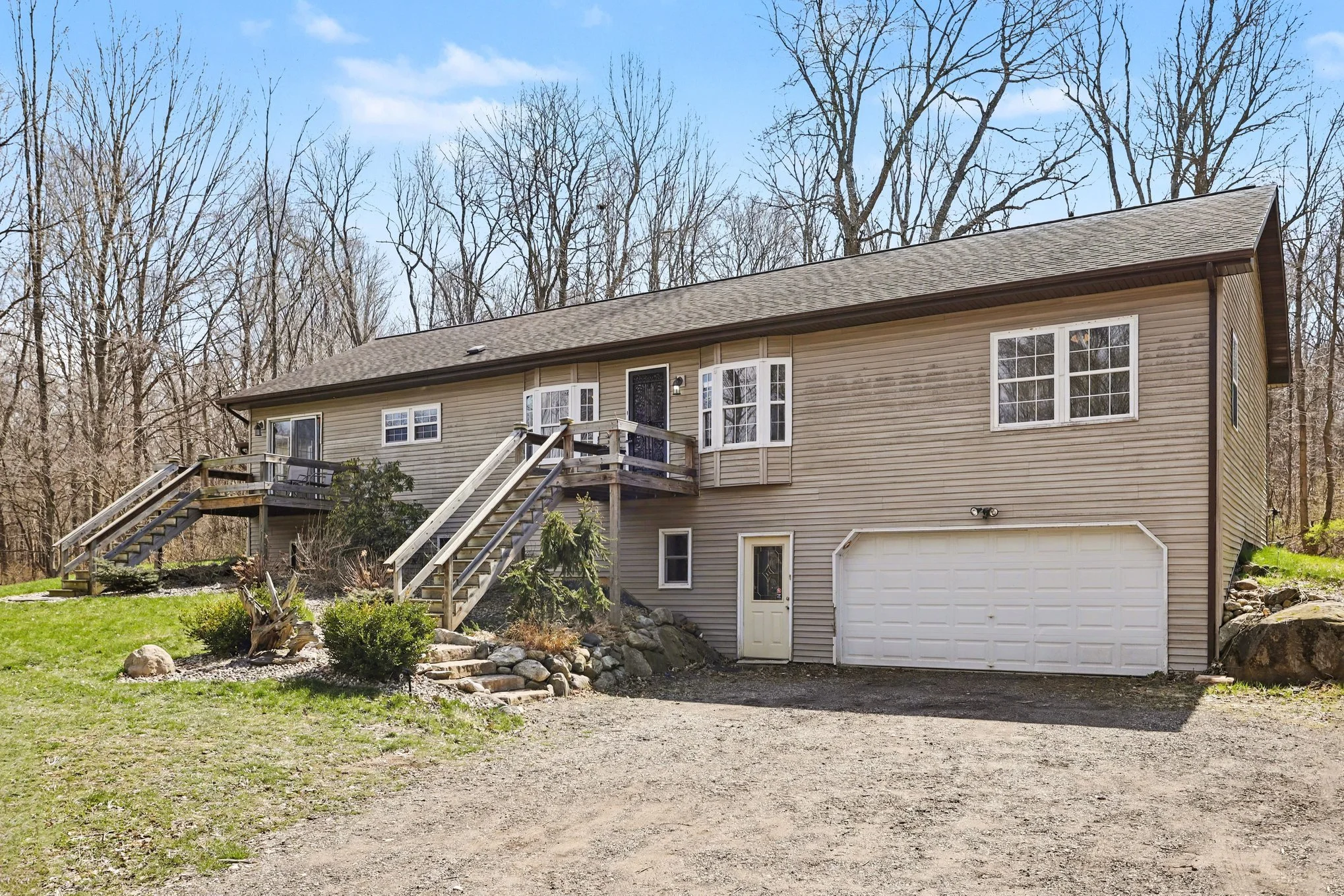 Front exterior of 6326 N 7th St Kalamazoo MI ranch home on 15 wooded acres with attached garage and private setting in Alamo Township