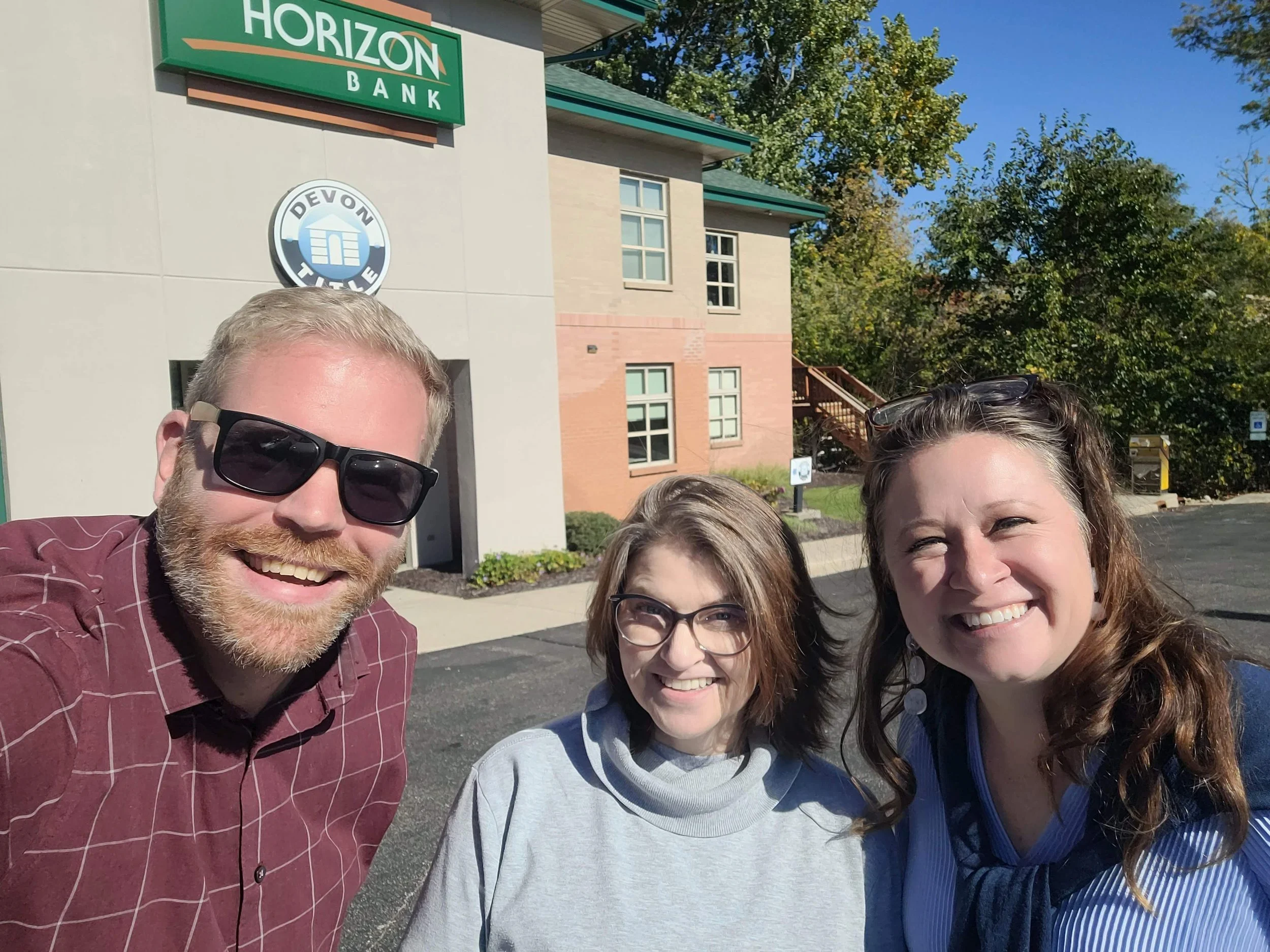 Post-closing photo of Tracy celebrating with Jason Veenstra from the Veenstra Team and Crystal Haydo with Allen Edwin Homes after closing on her new home in Portage, MI.
