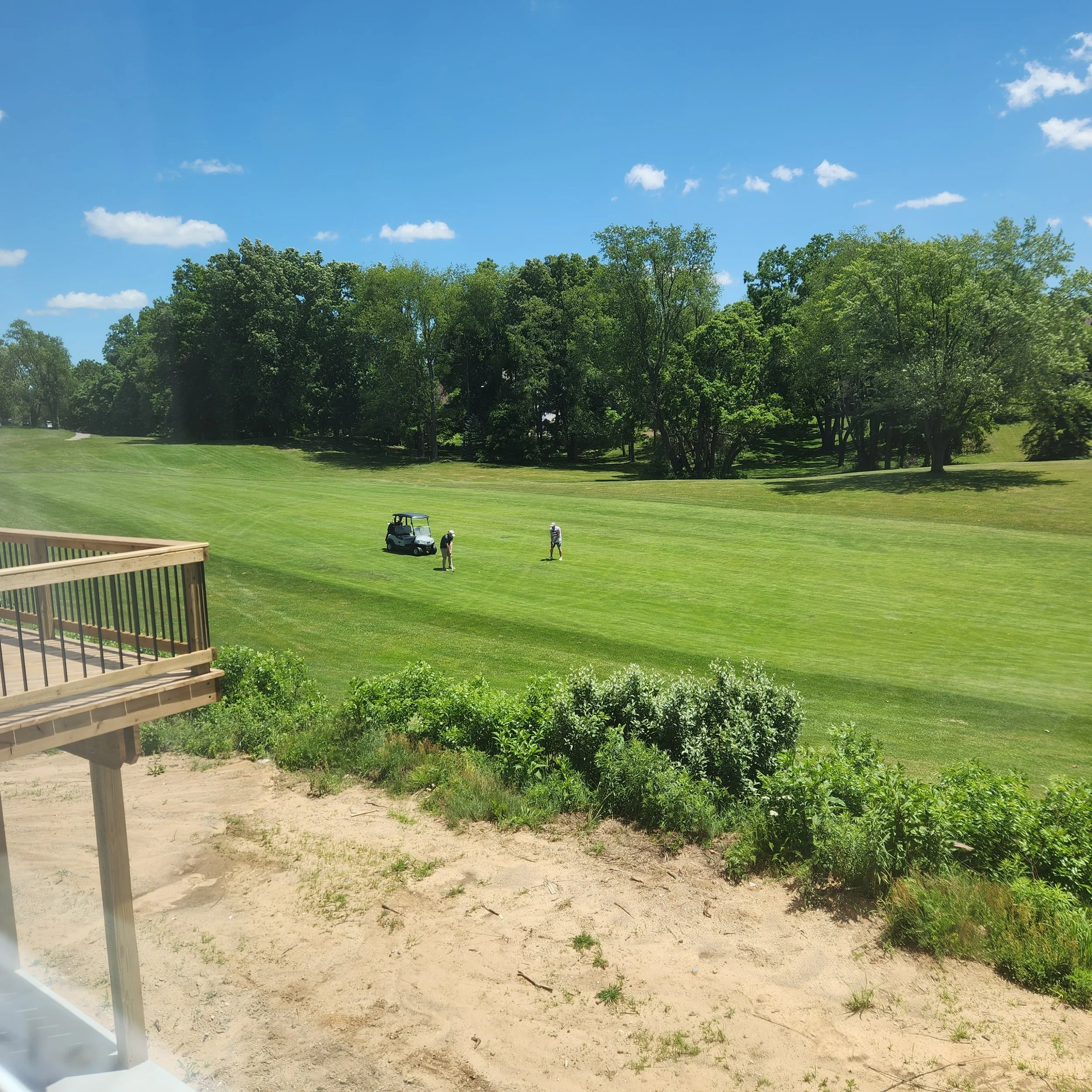 Two men golfing and a golf cart as shown from the patio of the house at 237 Markus Glen Drive, Plainwell, MI 49080