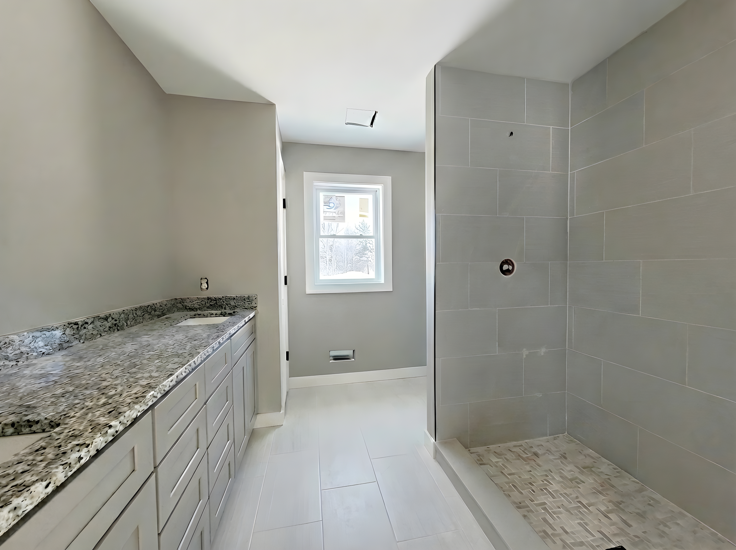 Primary bathroom in new construction home at 8683 Chamomile Drive in Augusta Michigan with unfinished fixtures and shower glass pending installation.