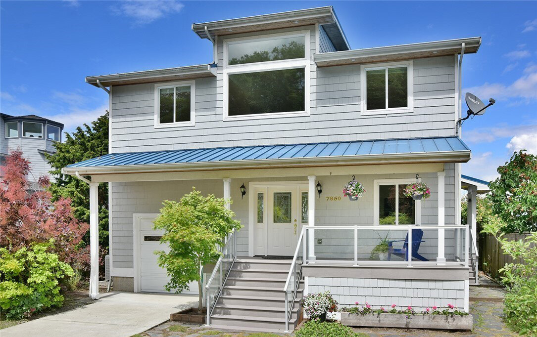  exterior of 2 story house with blue roof and garage on waterfront 