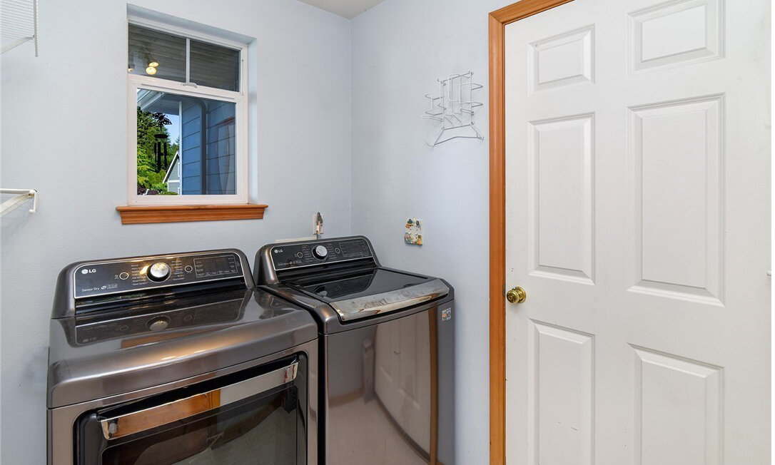  interior of storage room with washer and dryer and window 