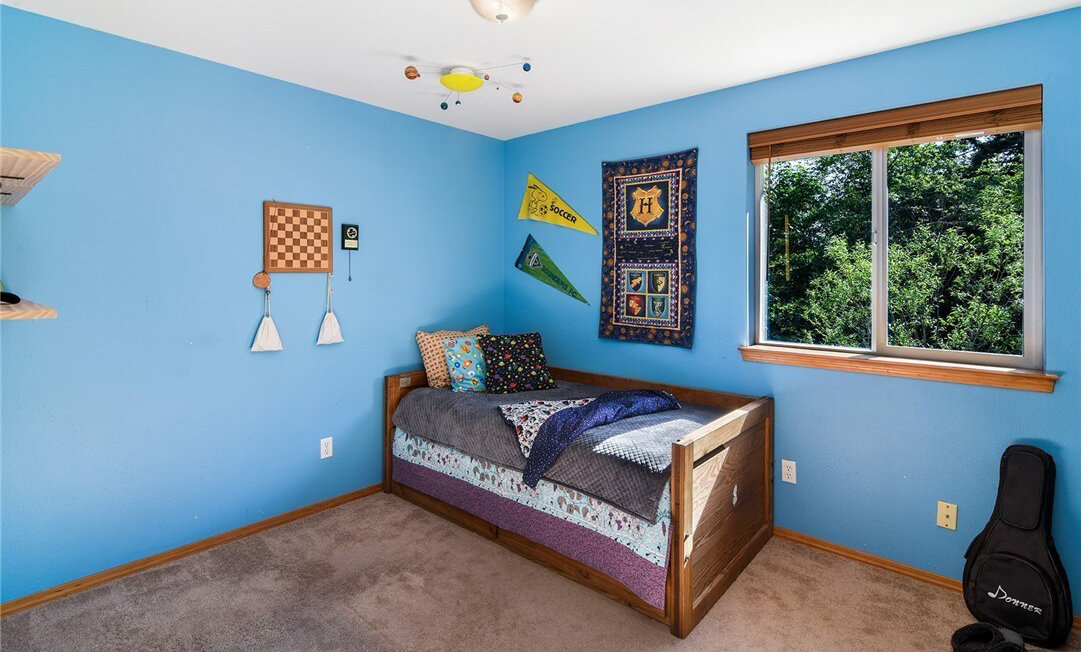  interior of childrens bedroom with window, carpet, and bed 