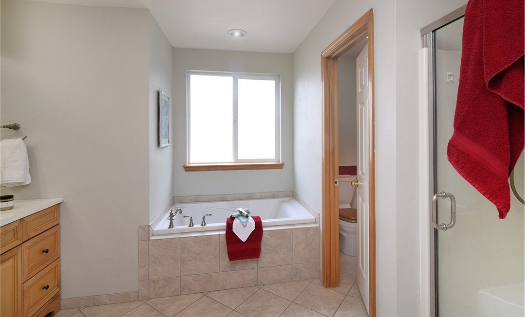 interior of bathroom with large tub and window 