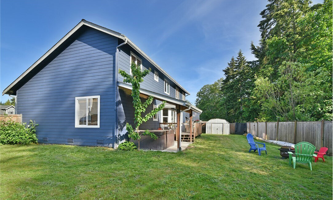  exterior of 2 story blue house with garage and yard 