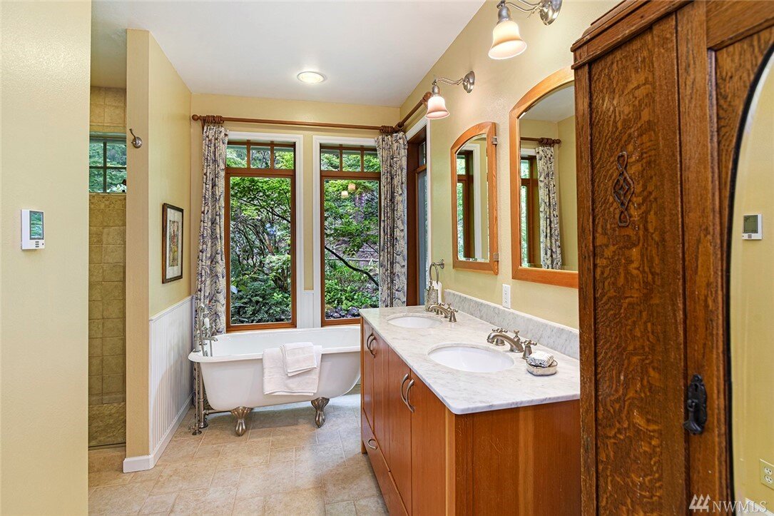  interior of bathroom with large windows, clawfoot tub, and 2 sinks 