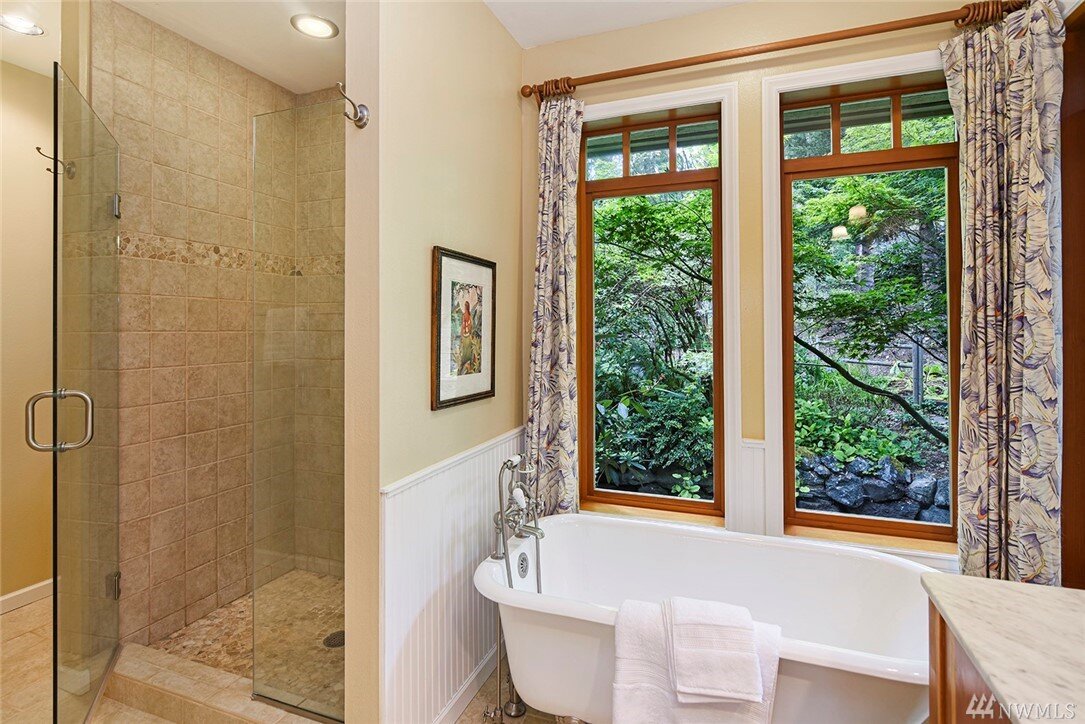  interior of bathroom with clawfoot tub and walk in shower 