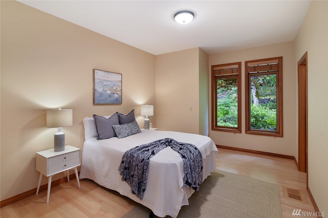  interior of bedroom with 2 windows and queen bed 