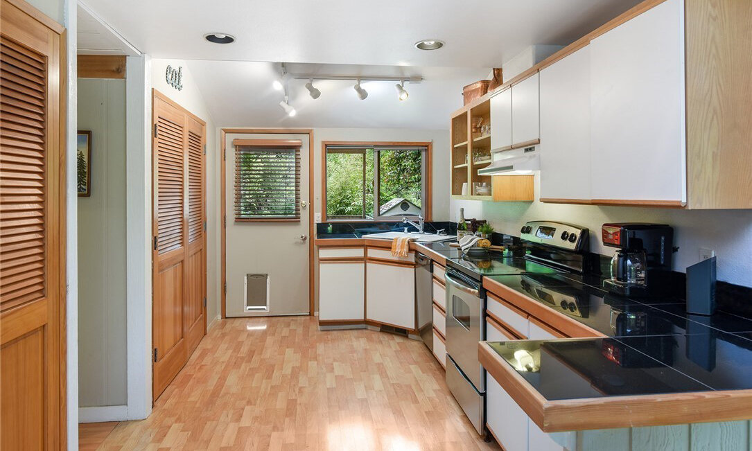  interior of kitchen with hardwood floors, windows, and pantry 