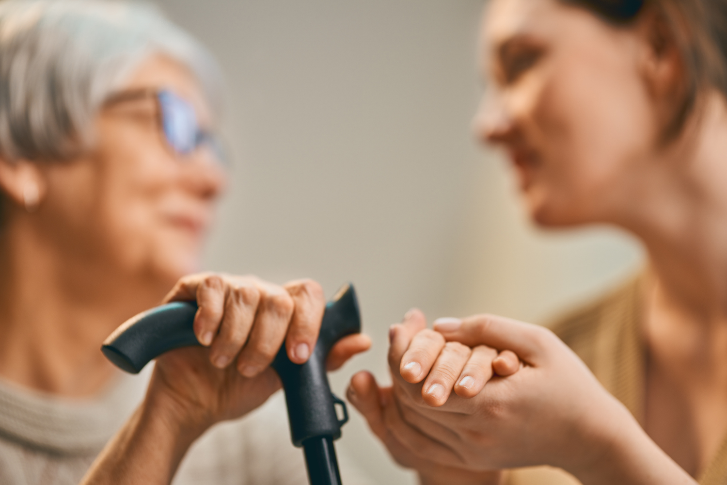 Caregiver holding an elderly patient’s hand, representing support during cancer care and treatment decisions.