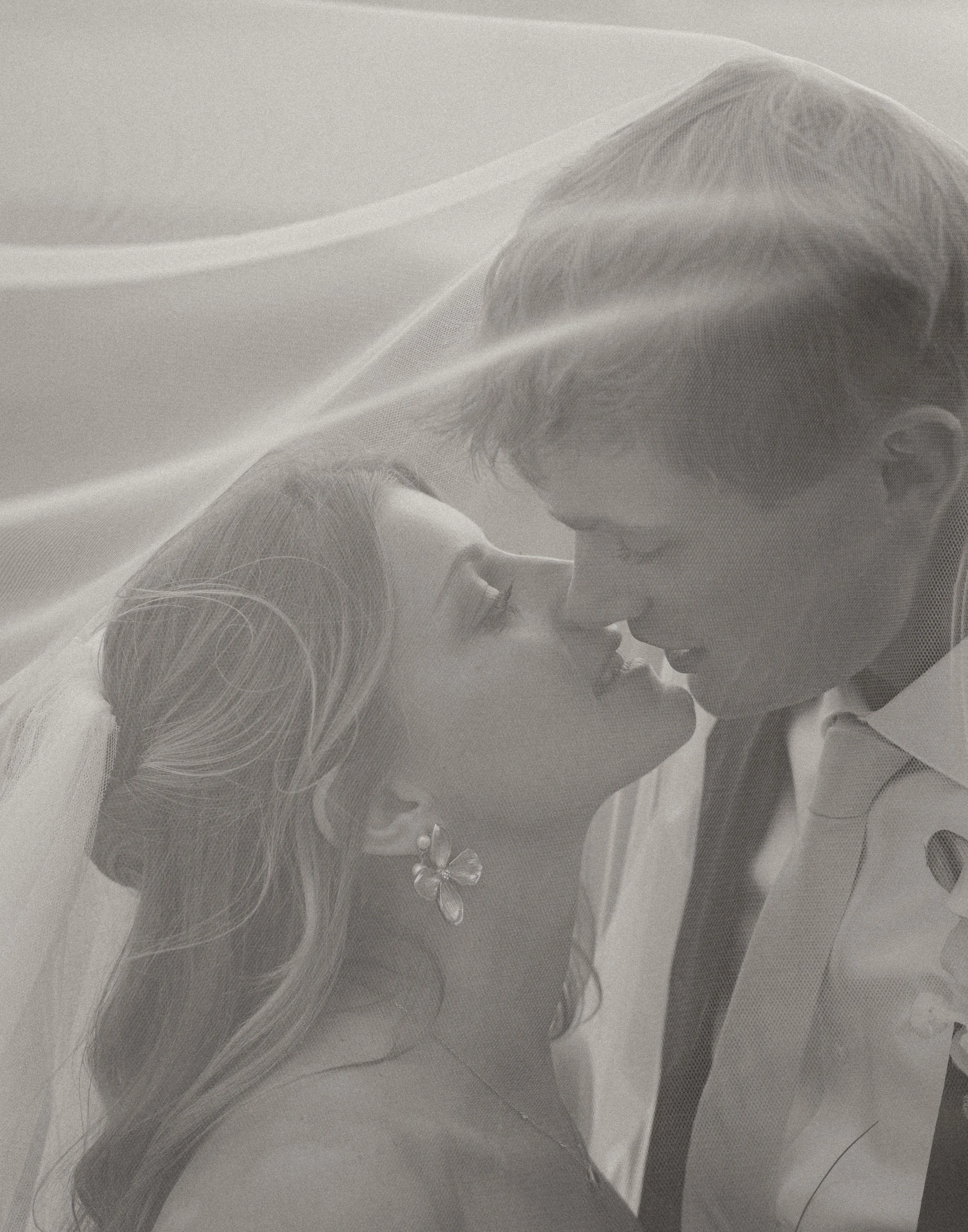 Black and white photo of bride and groom about to kiss.