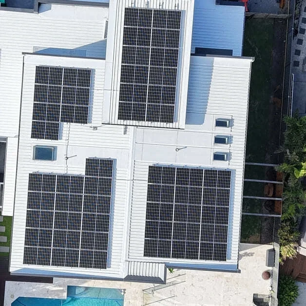 A rooftop with multiple solar panels installed on white roofing.