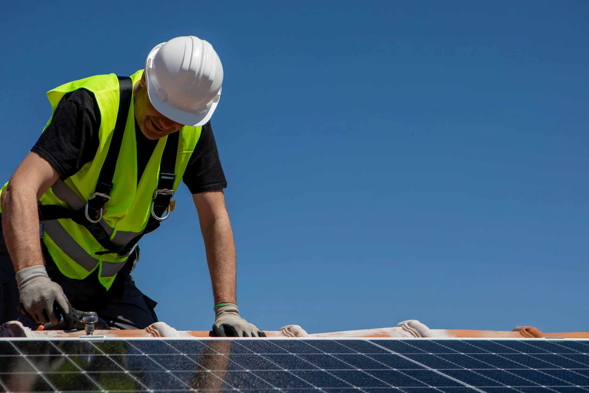 Solar electrician installing panels on Gold Coast home roof