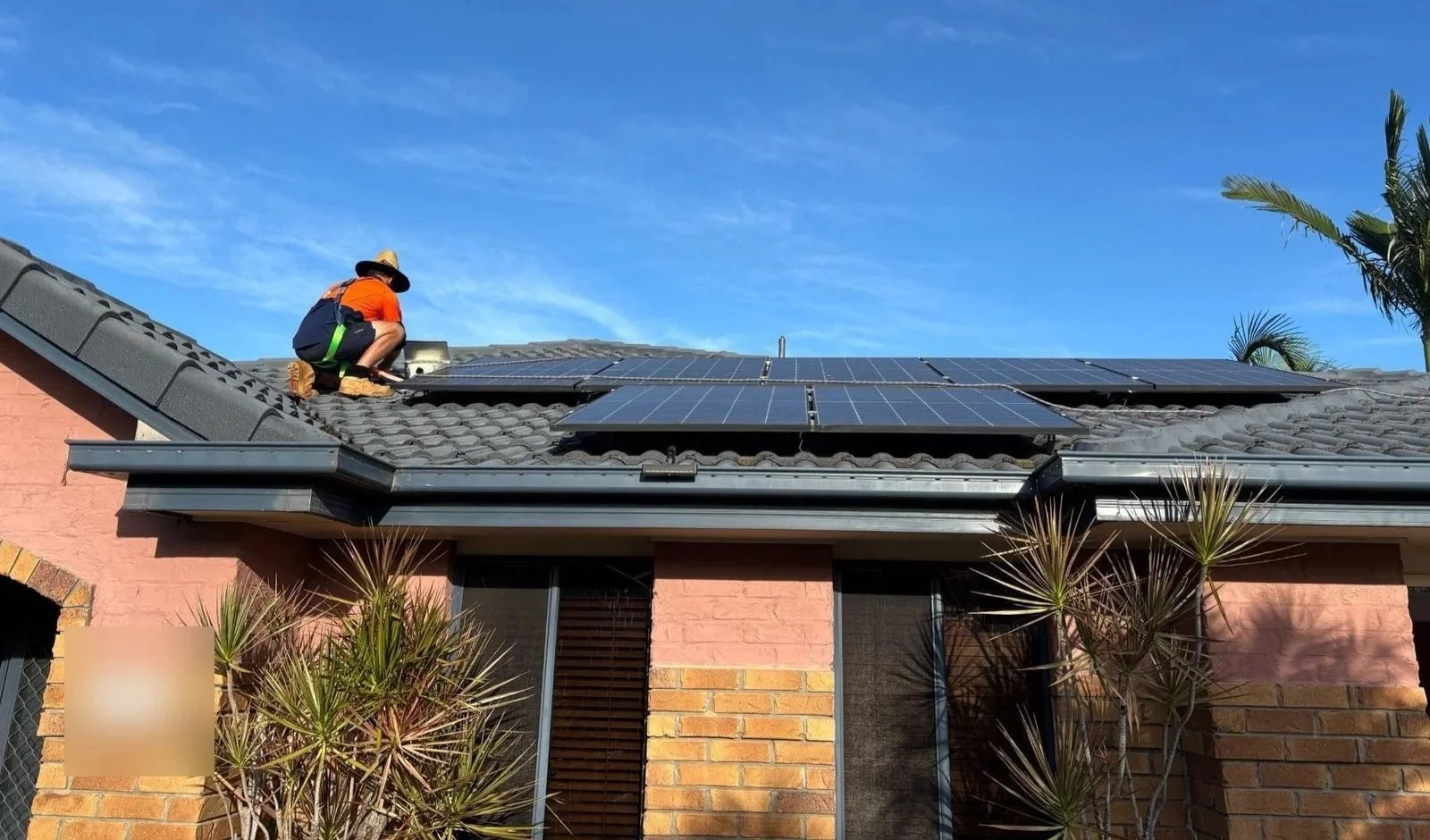 Evolved Solar installer working on the existing rooftop solar array at a Molendinar home