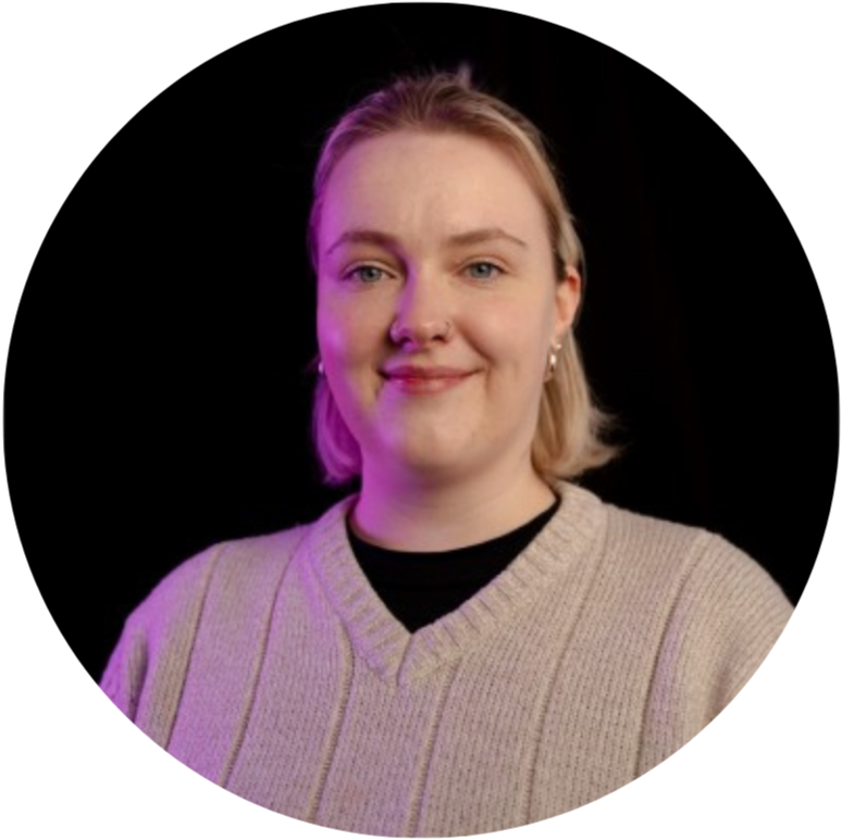 Woman with blonde hair and nose ring smiling indoors