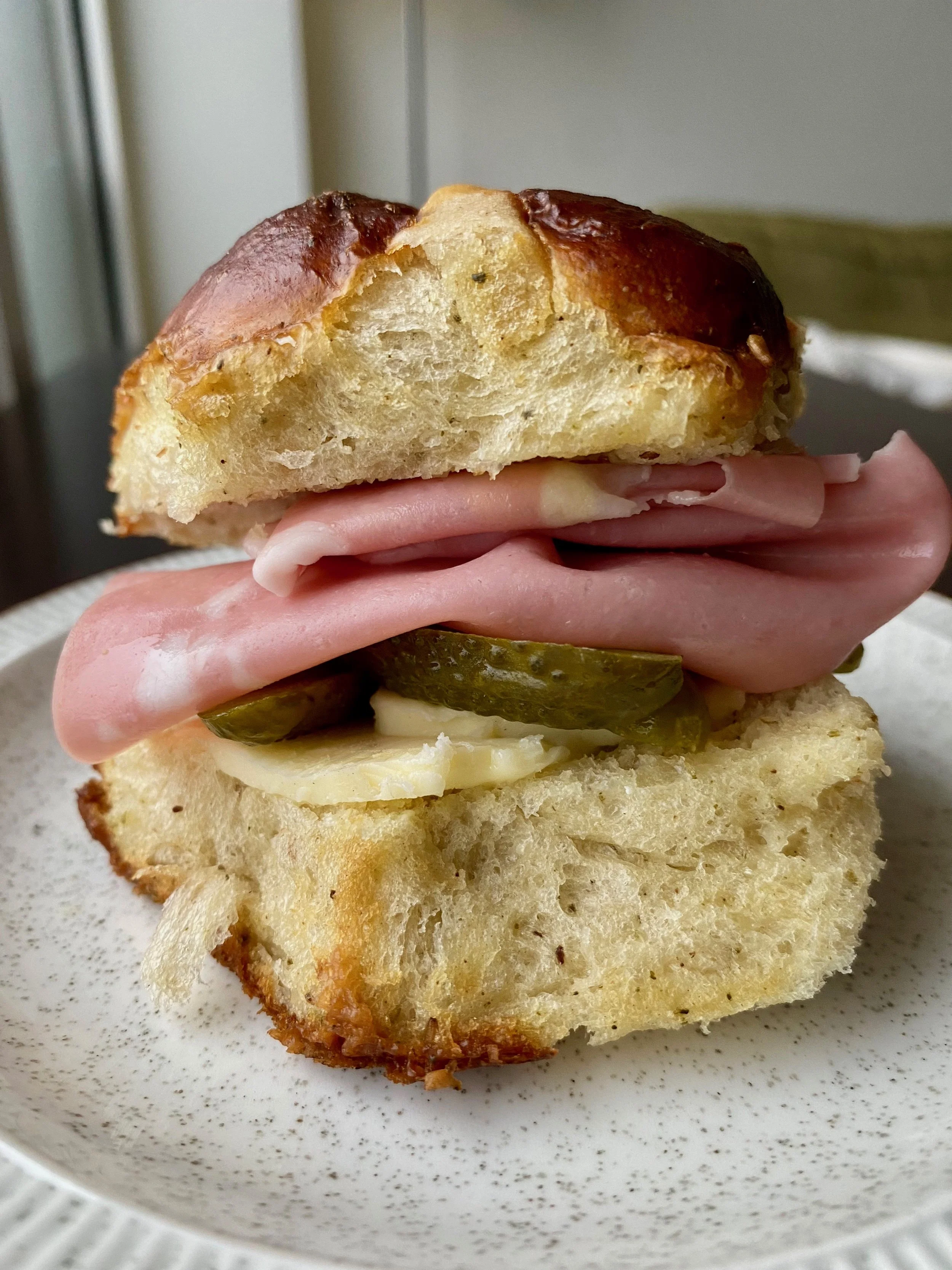 Jambon beurre made with pretzel cheddar and za'atar hot cross buns with mortadella, butter slabs and cornichons.