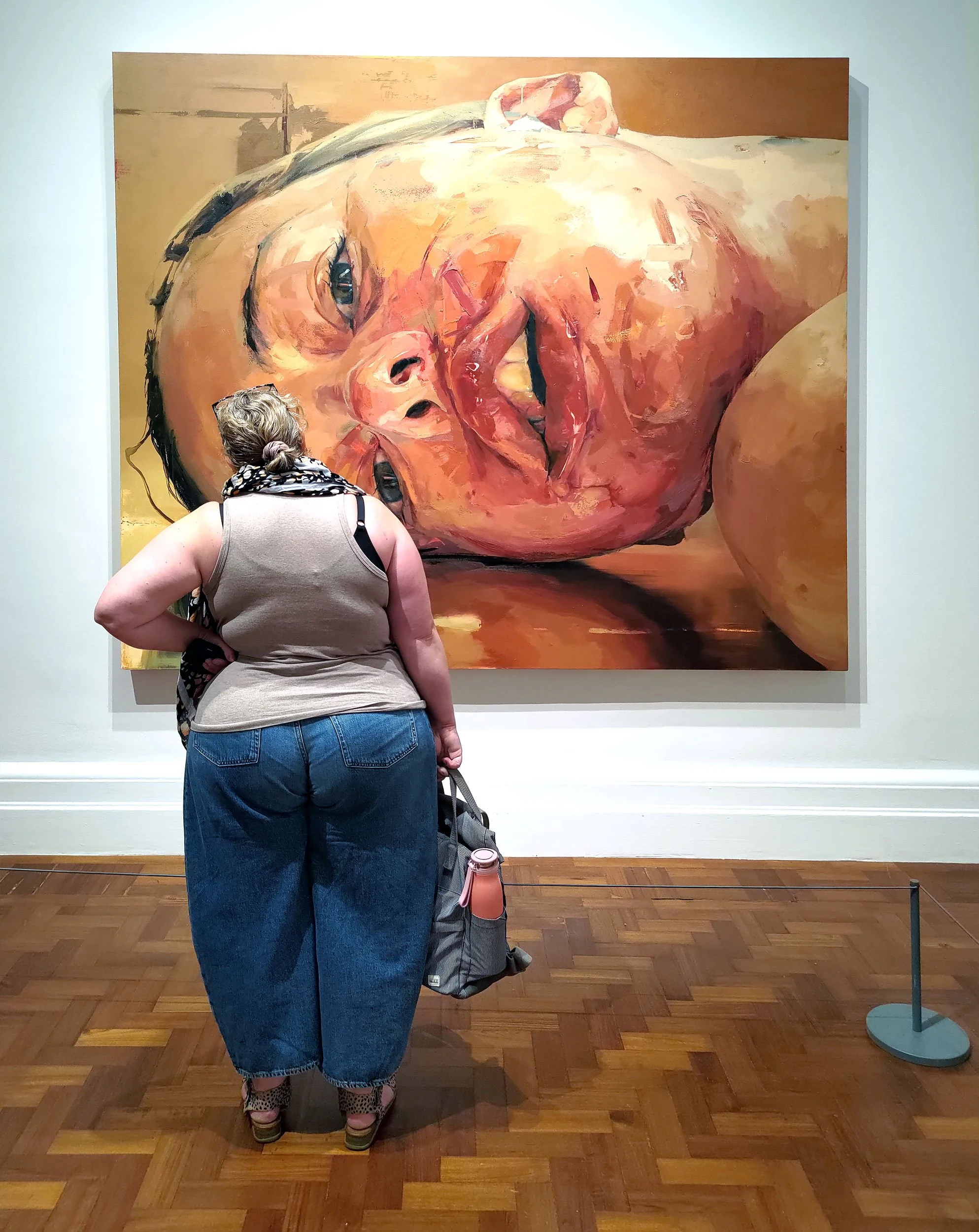 Woman looking at Jenny Saville painting