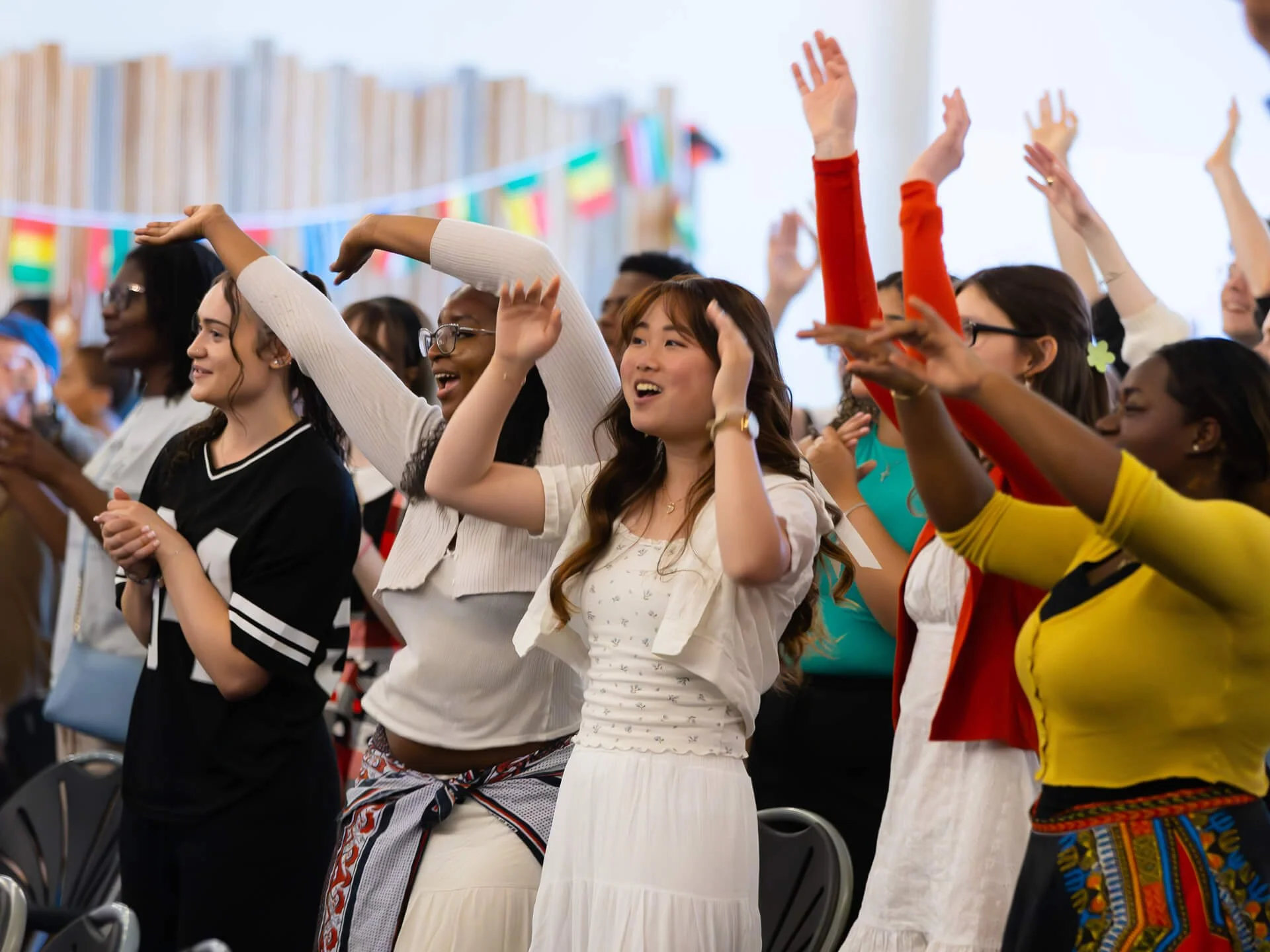 A multicultural group of students and young adults worshipping and praising God during a Citygate church service, many with their arms raised. It's All Nations Sunday, where we as a church family celebrate the different cultures in our congregation.