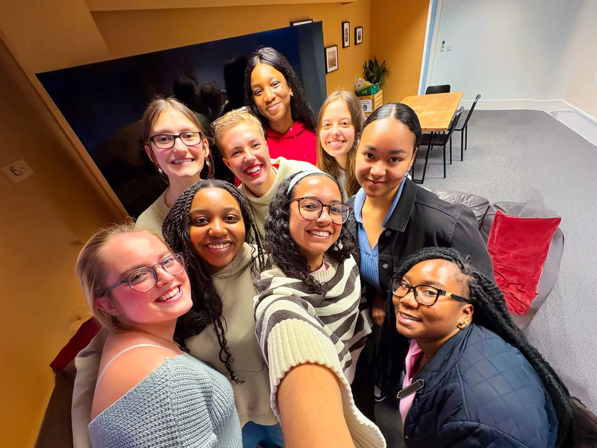 A diverse group of young, joyful, Christian women, taking a selfie, after their first session of the 'Freedom in Christ' course.
