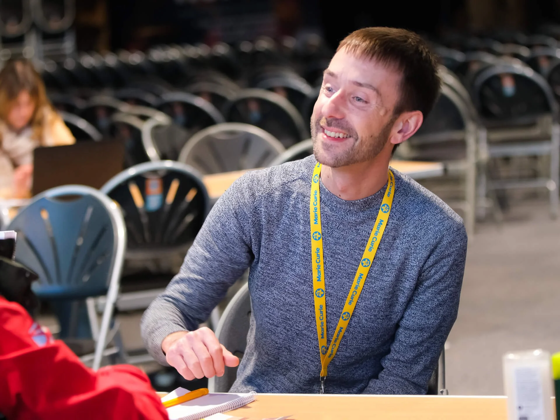 A friendly young man is chatting to a visitor, offering them help, guidance, and a listening ear.