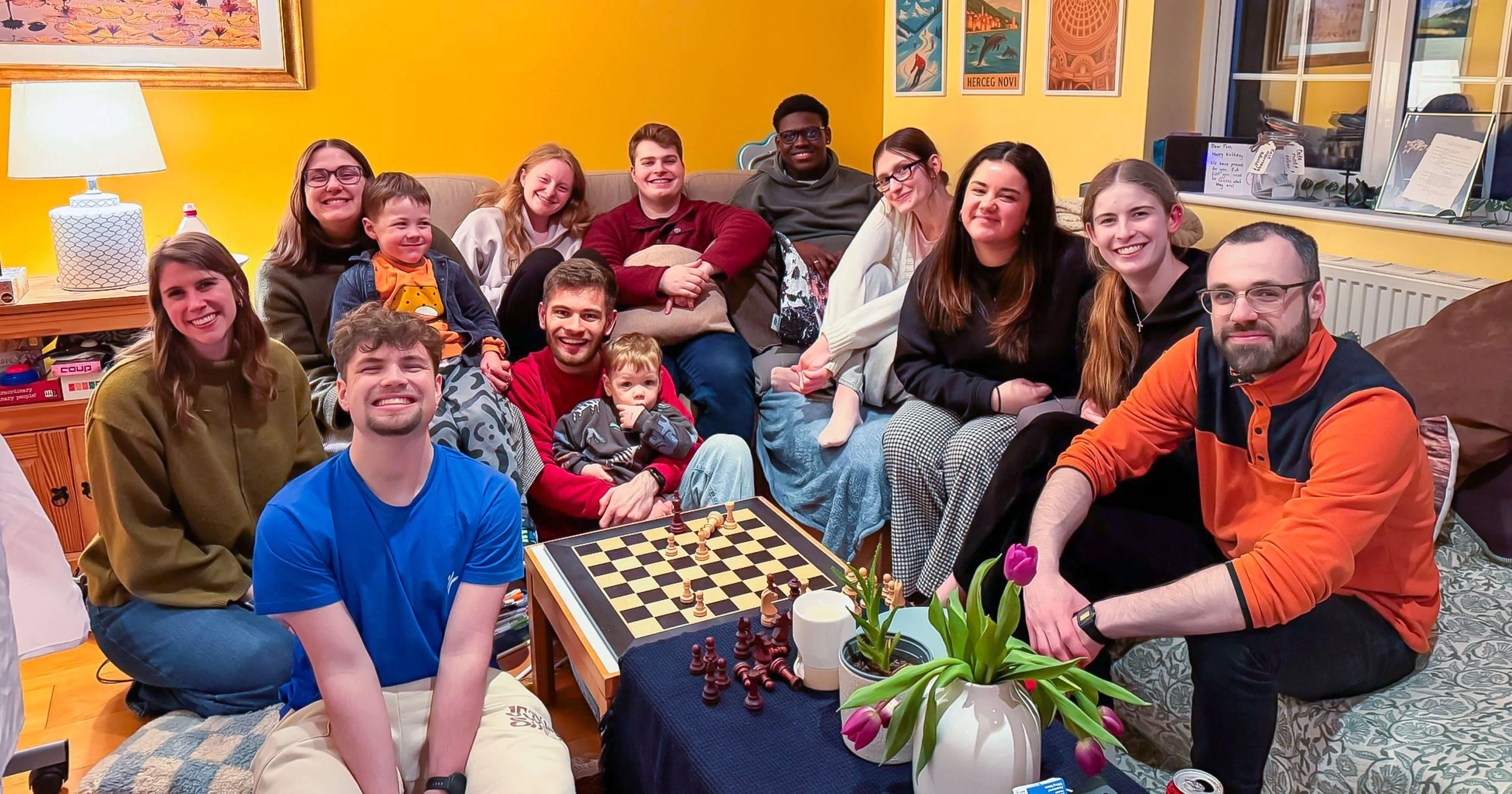 A group of young, smiley church interns, sat around their Bible leader's home, enjoying games, socializing and fellowship.