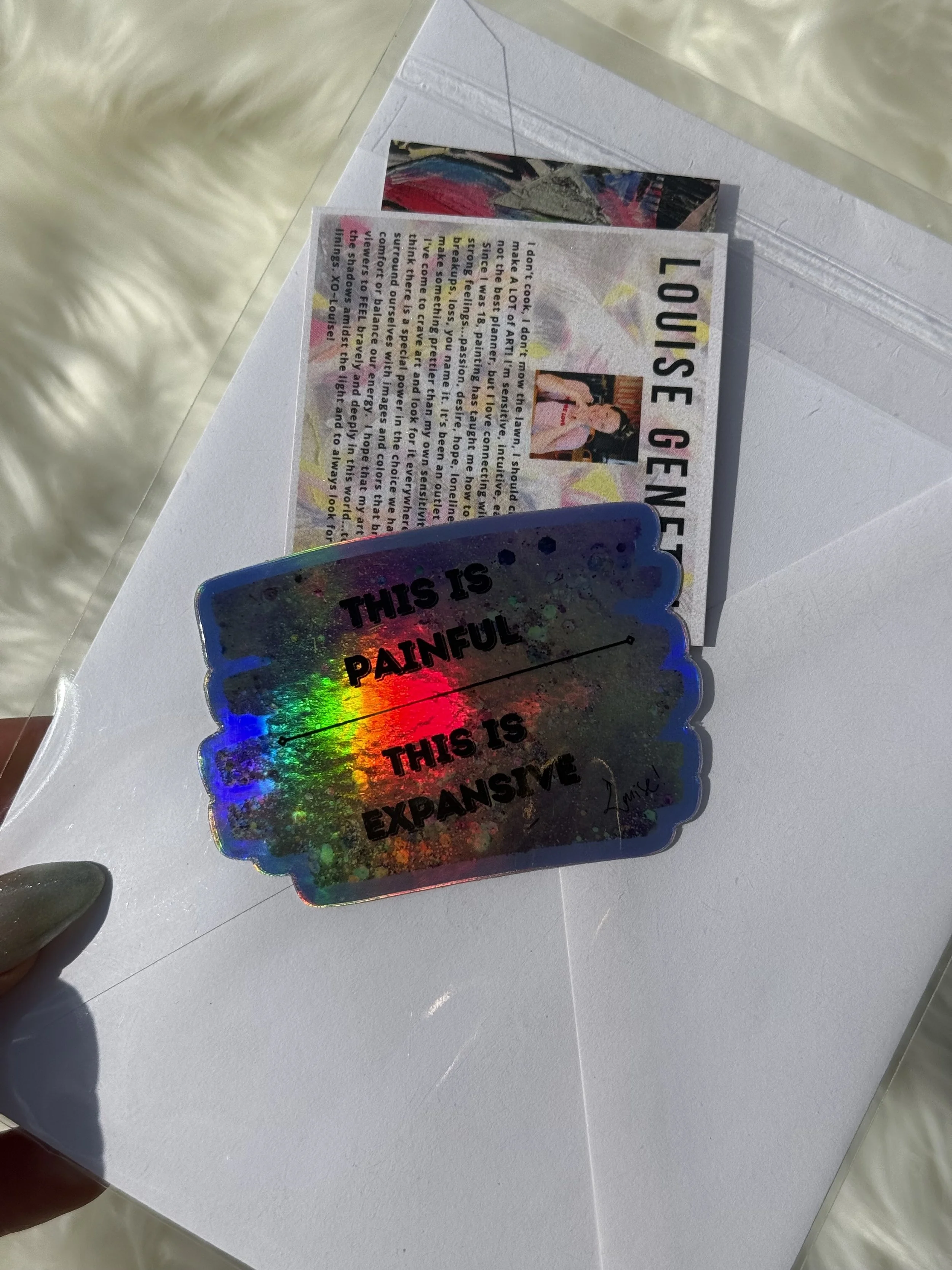 back is blank | Sealed with envelope and vinyl waterproof sticker that reads "This is Painful | This is Expansive" and small artist statement card