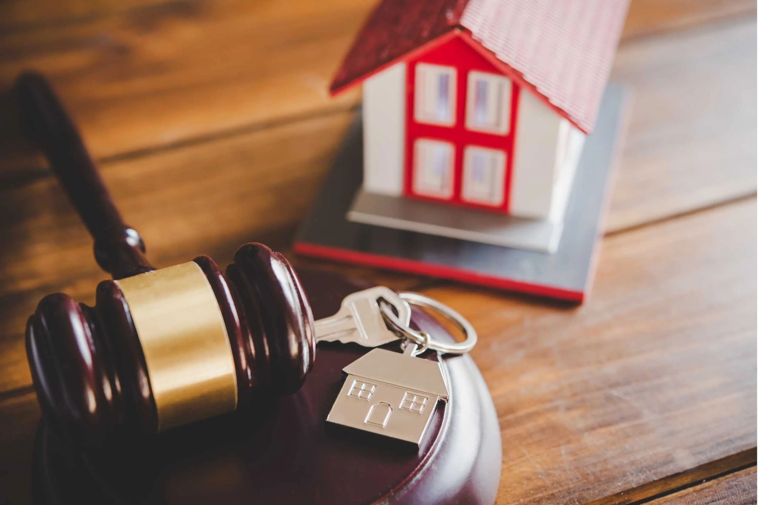 Judge's gavel, house key, and model home representing probate, inheritance rights, and estate administration when someone dies without a will in Ohio.