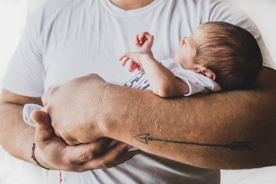 Father holding an infant, illustrating fatherhood, parenting education, and support for new dads.
