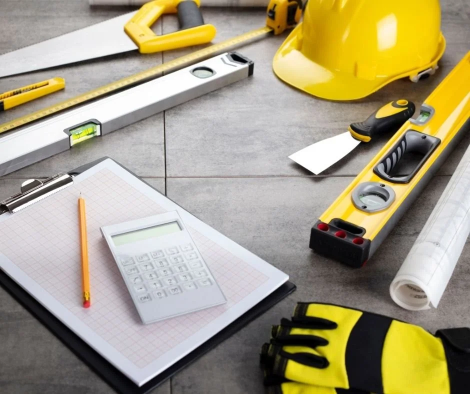 Construction tools, blueprint plans, and safety helmet on a work surface, representing contractor disputes, construction defects, and project-related legal issues.