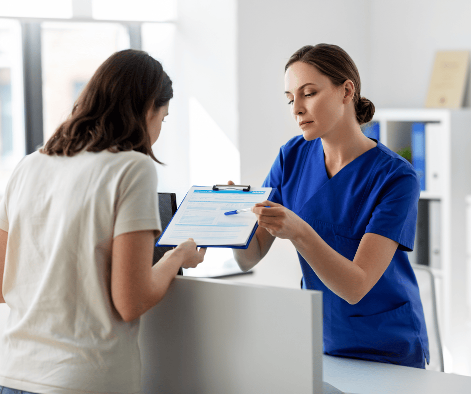 Healthcare professional handing a clipboard with a form across a counter, symbolizing the legal right to access medical records through HIPAA authorization in Northeast Ohio.