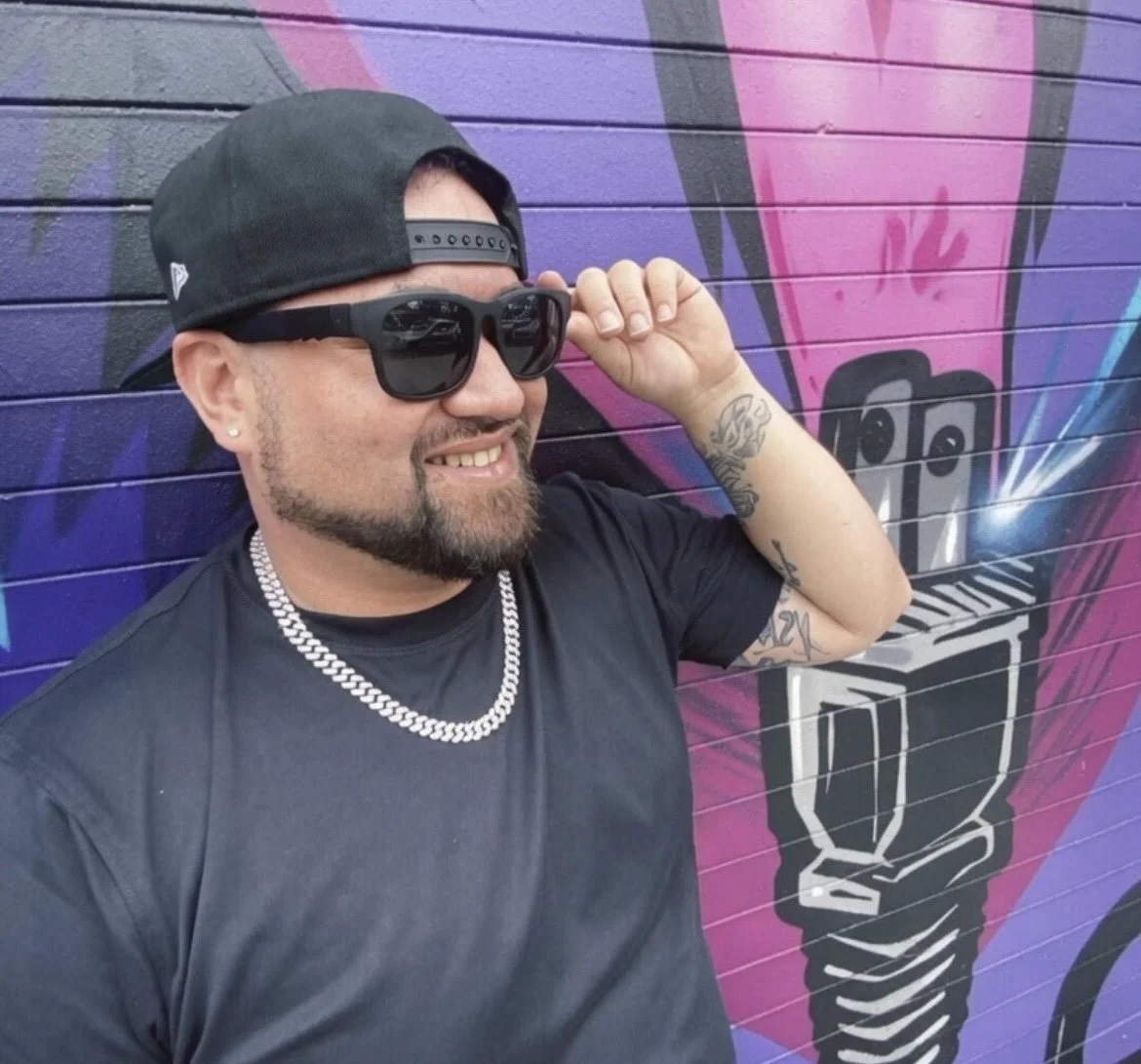 man with backwards hat wearing dark sunglasses